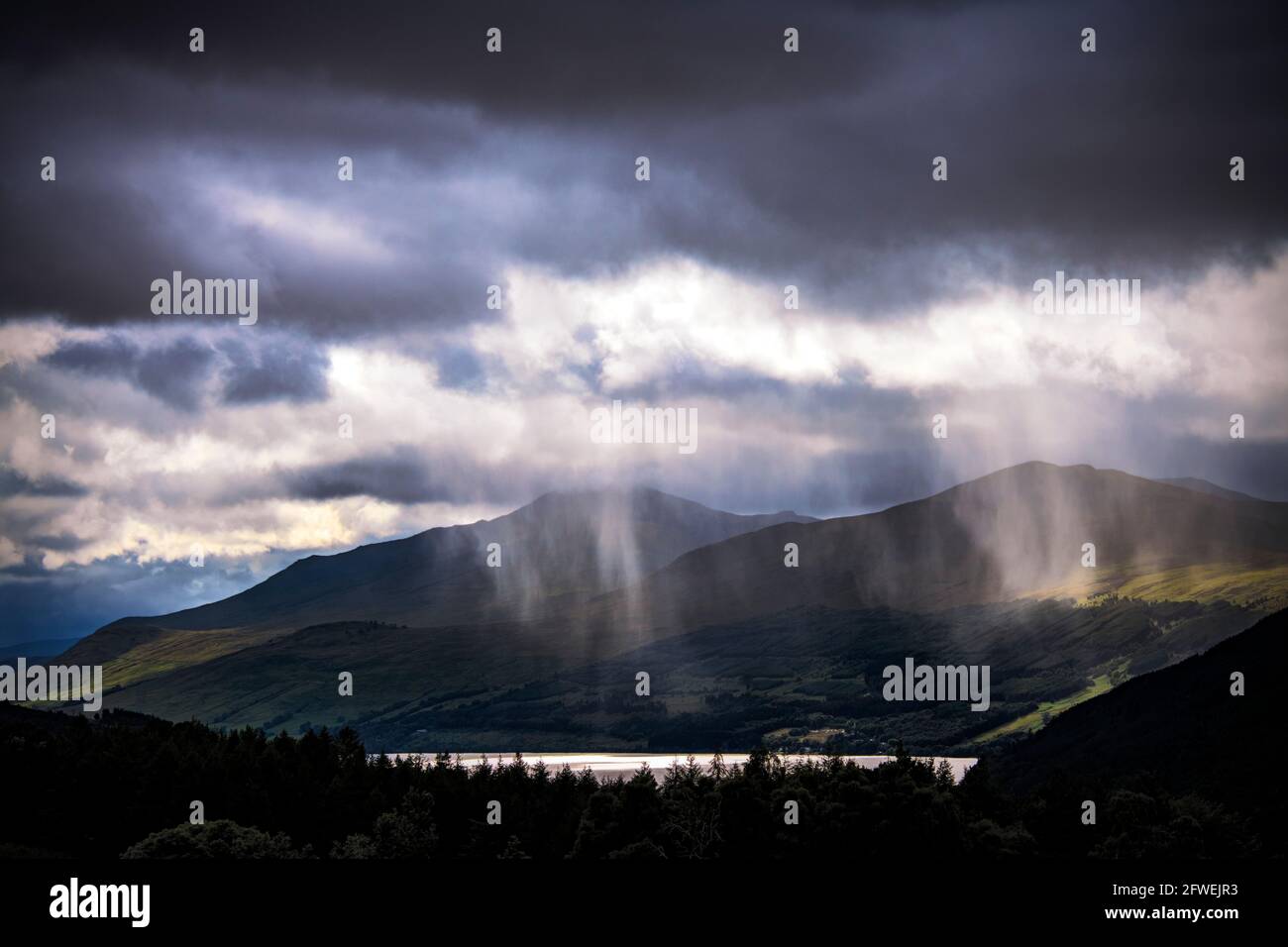 Docce a pioggia su Loch Tay e sulle colline della catena montuosa Ben Lawers, Scozia Foto Stock