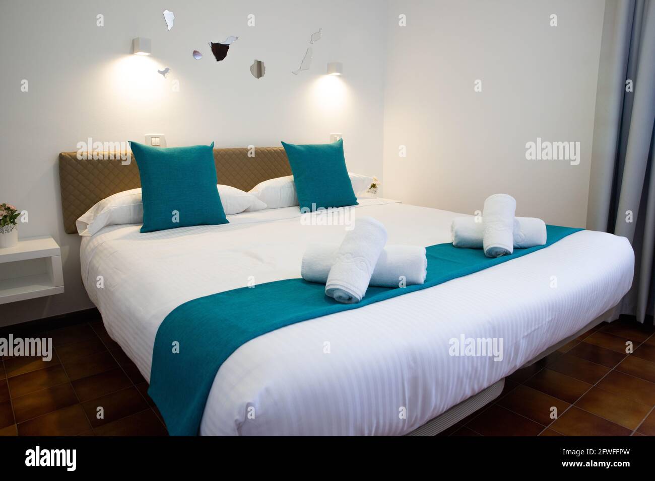 Letto matrimoniale con asciugamani ripiegati in cima, all'interno di una camera da letto. Foto Stock