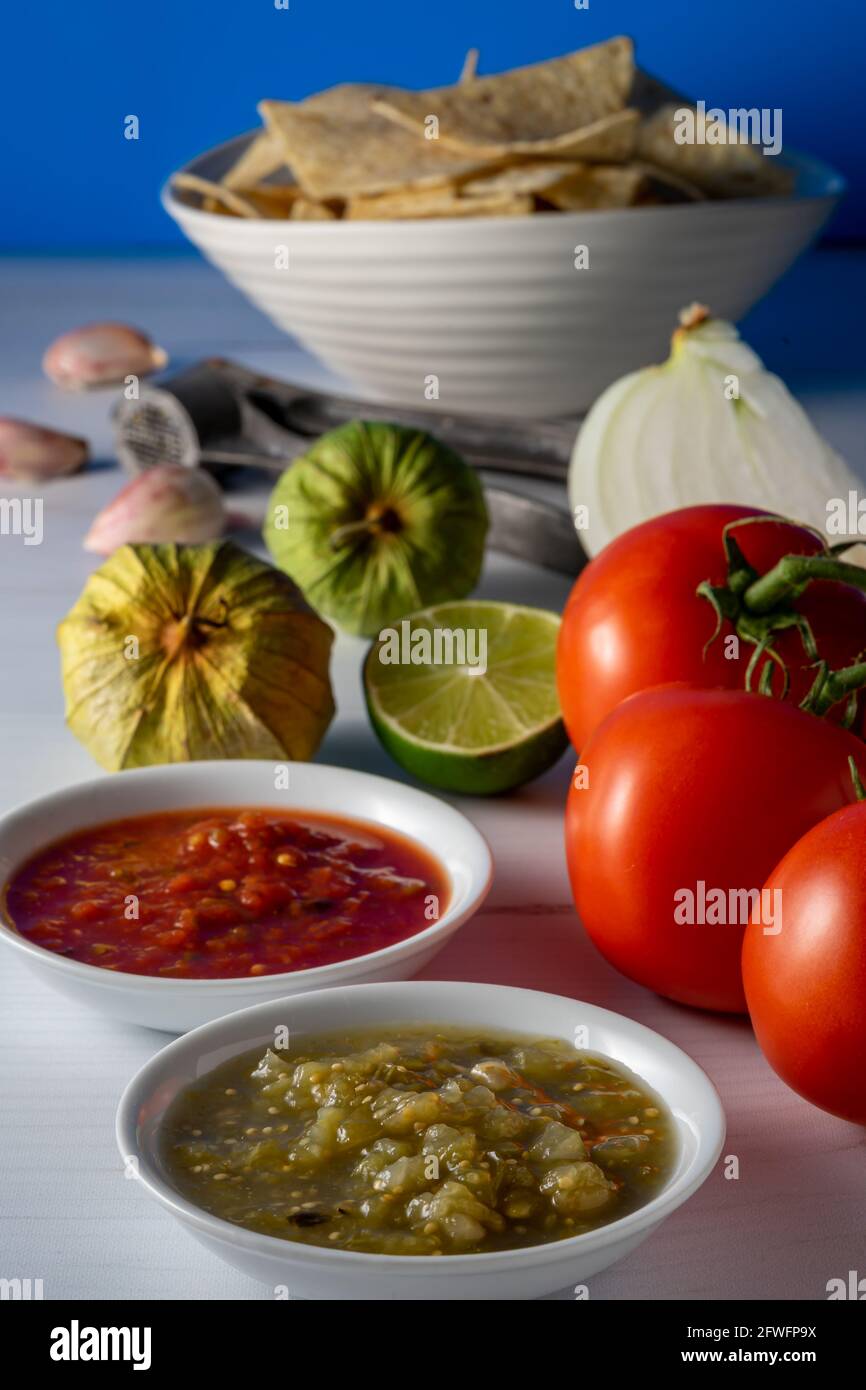 Tortilla di mais e salsa con ingredienti crudi. Foto Stock