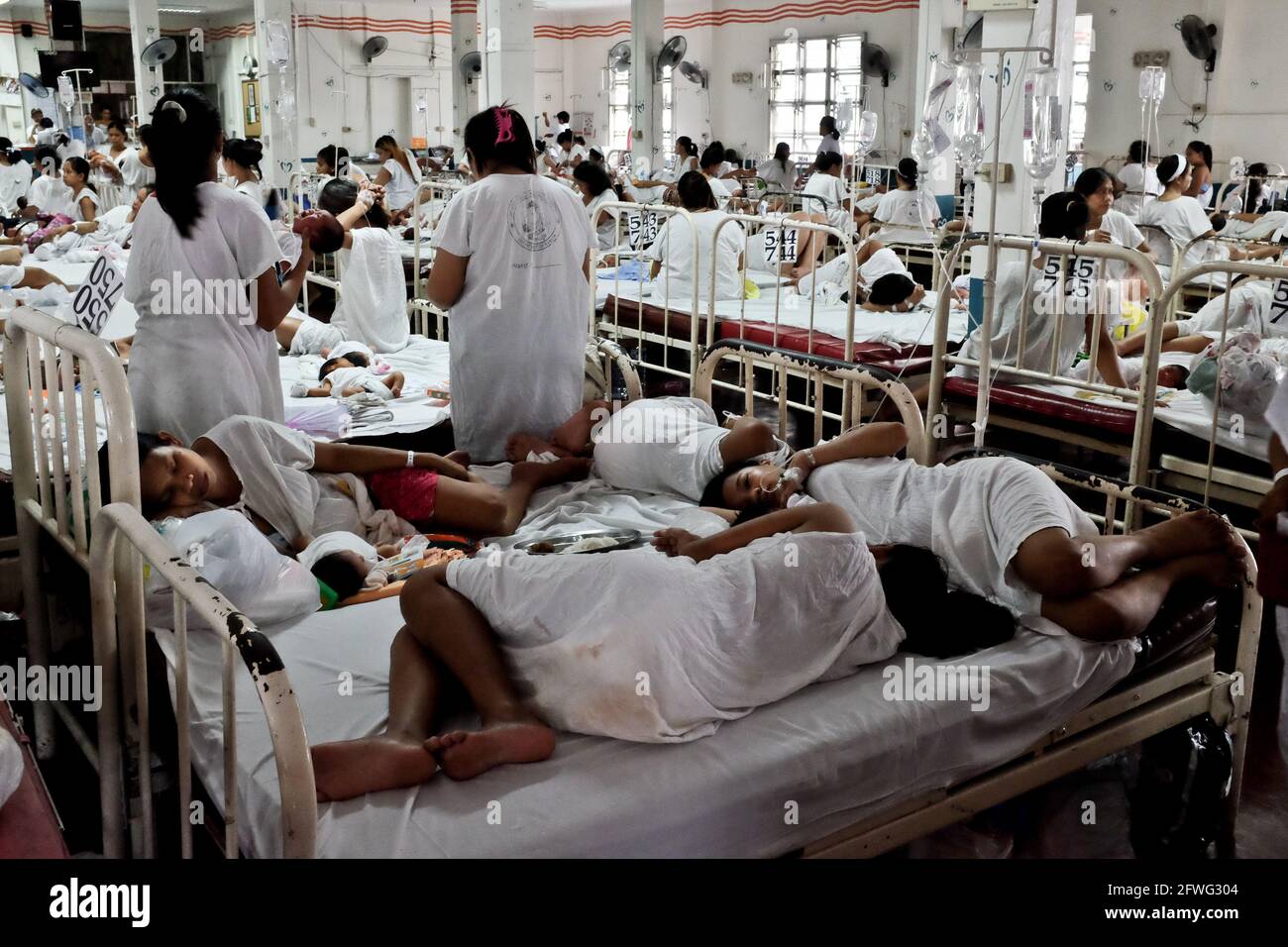 Madri esauste nel reparto di maternità dell'ospedale Jose Fabella a Manila, Filippine. È considerato il più trafficato del mondo. Foto Stock