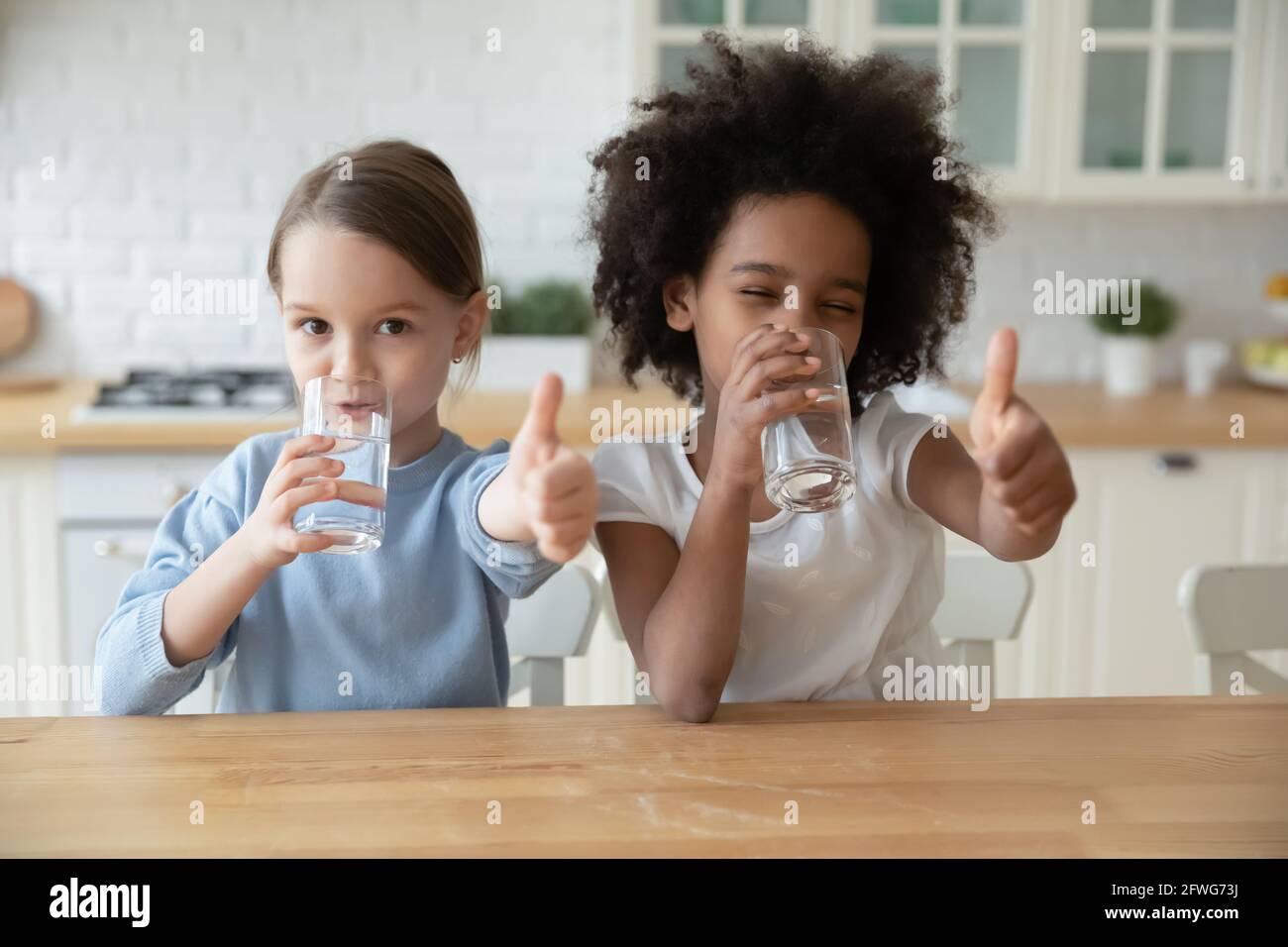 Ritratto di sorridenti ragazze multietniche bere acqua Foto Stock