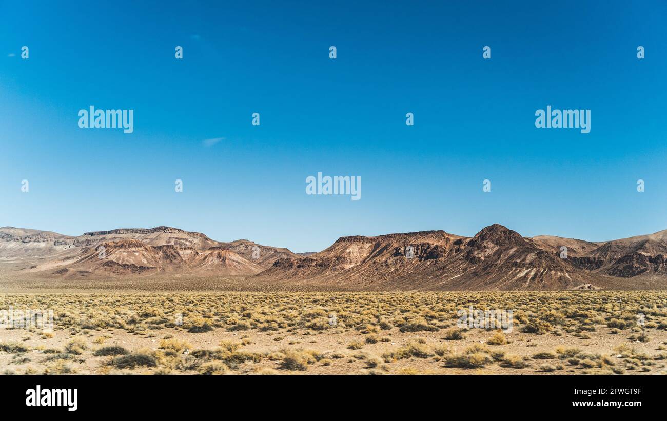 Aride Montagne paesaggio contro cielo blu chiaro in Nevada in deserto alto Foto Stock