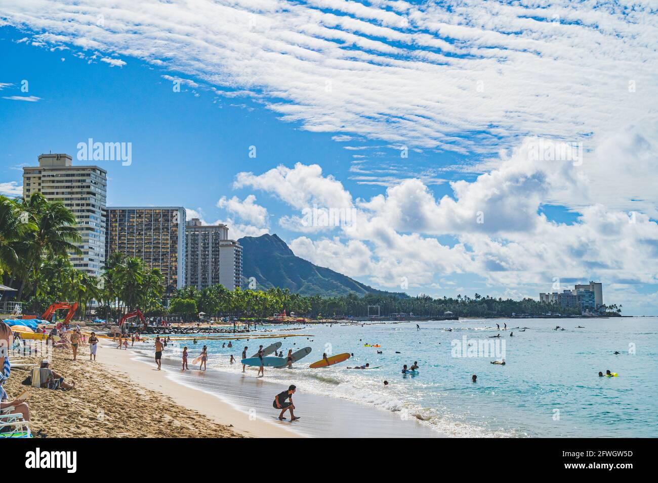 Oahu, Hawaii Novembre 15 2019: Persone che godono le calde acque al largo di Waikiki spiaggia con Diamond Head in background surf, prendere il sole e rilassarsi. Foto Stock