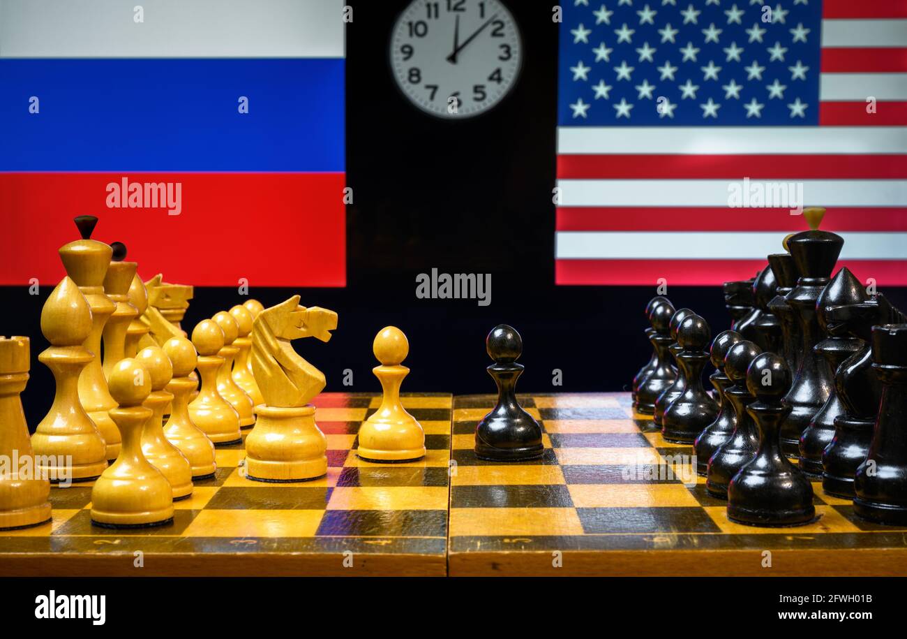 Russia vs USA, scacchi come gioco geopolitico. Bandiere di Stati Uniti e Federazione russa dietro scacchiera. Concetto di tensione politica, guerra economica Foto Stock