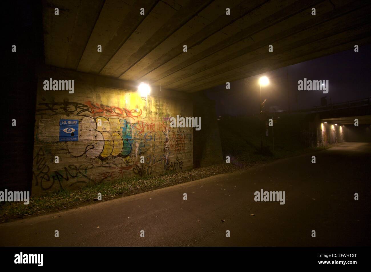 Vicolo sotto un ponte con graffite sul muro Foto Stock