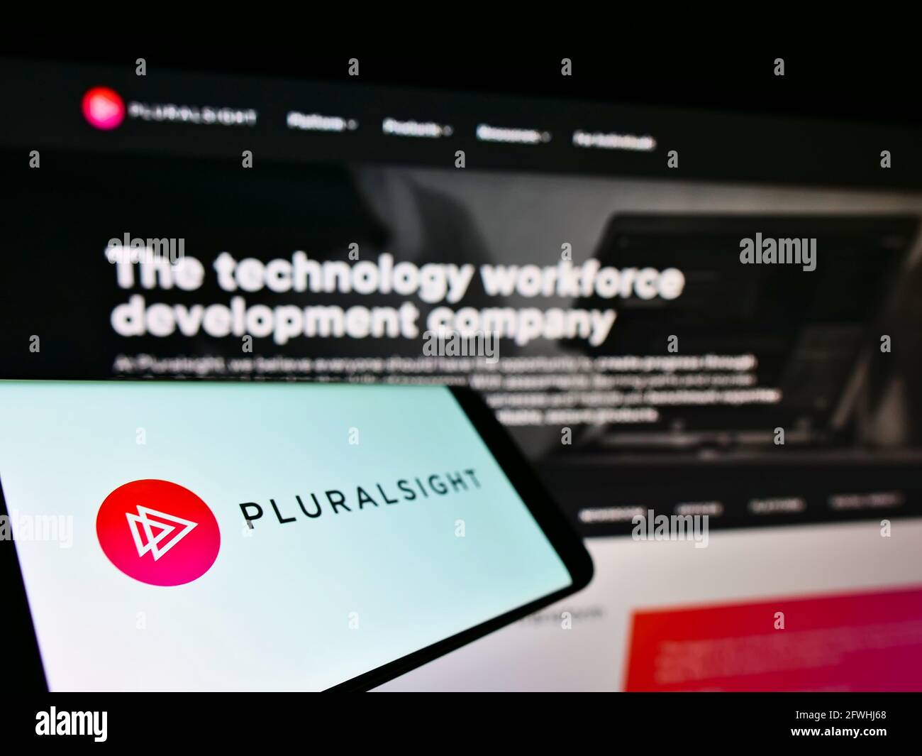 Smartphone con logo aziendale della società di formazione online statunitense Pluralsight Inc. Sullo schermo davanti al sito Web. Mettere a fuoco al centro-sinistra del display del telefono. Foto Stock