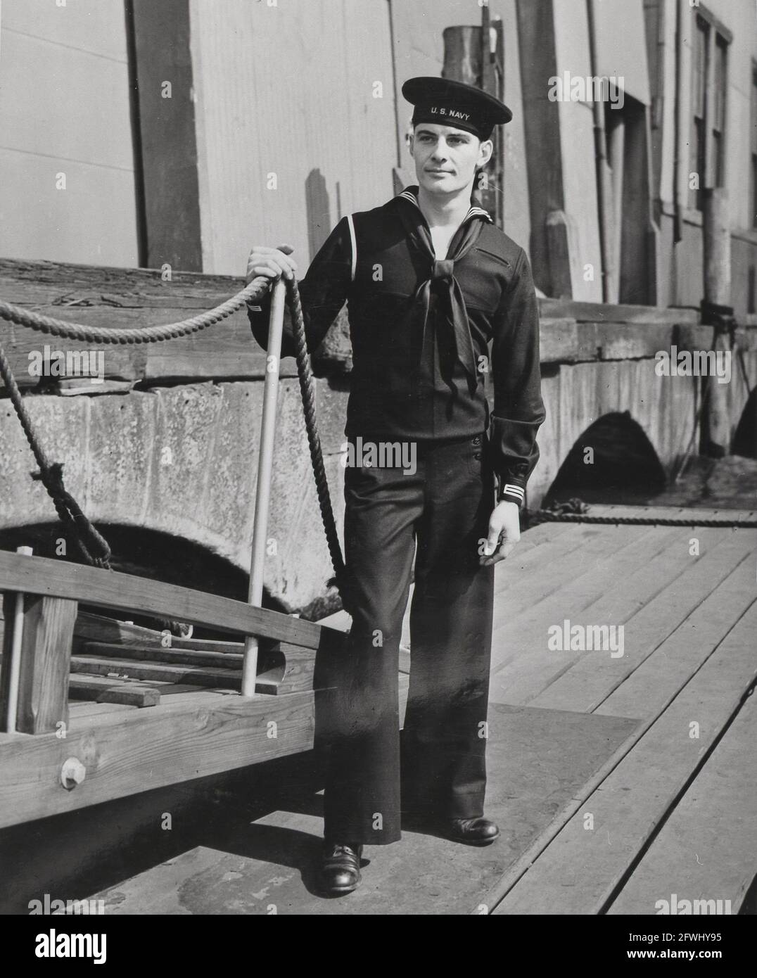 USA la seconda guerra mondiale degli anni '40 della seconda guerra mondiale Sailor della marina statunitense si pone su un molo per mostrare i suoi abiti da lavoro Foto Stock