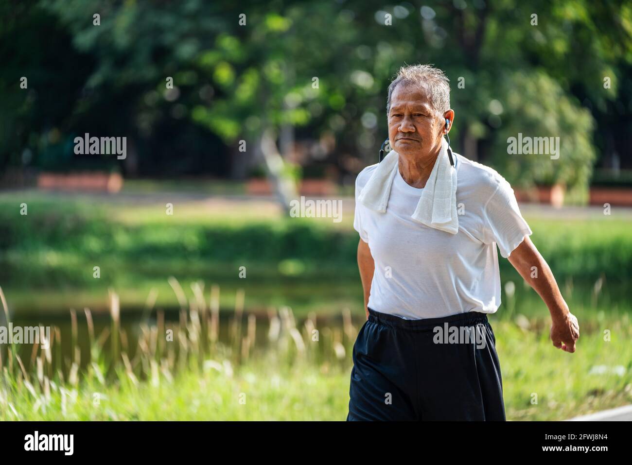 Asian senior maturo braccio swing e jogging nel parco per una buona salute. Foto Stock