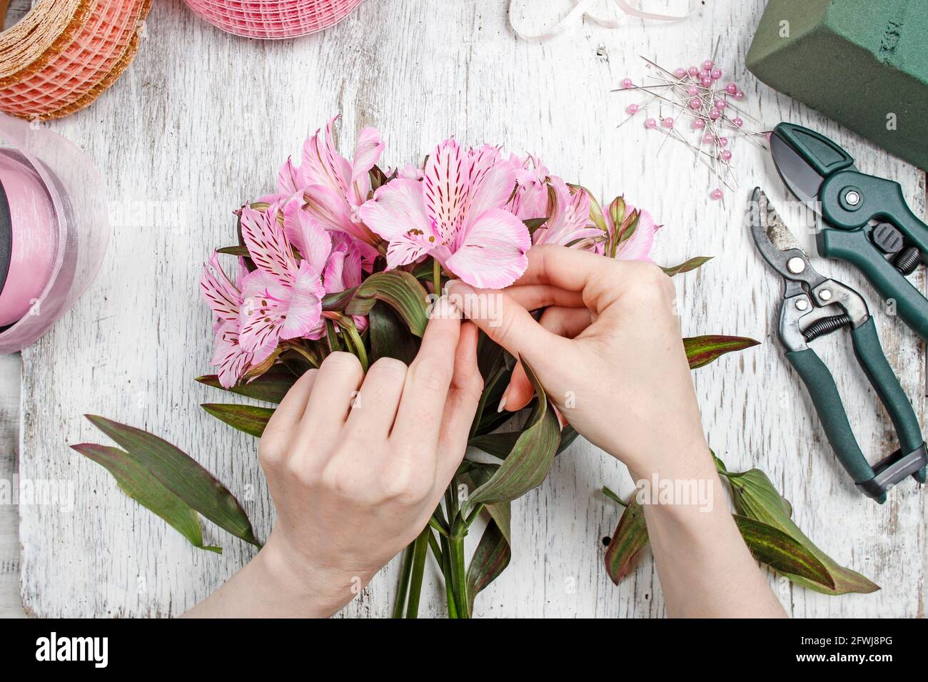 Fiorista al lavoro: Donna che organizza bouquet di fiori di alstroemeria comunemente chiamato il giglio peruviano o giglio degli Inca. Foto Stock