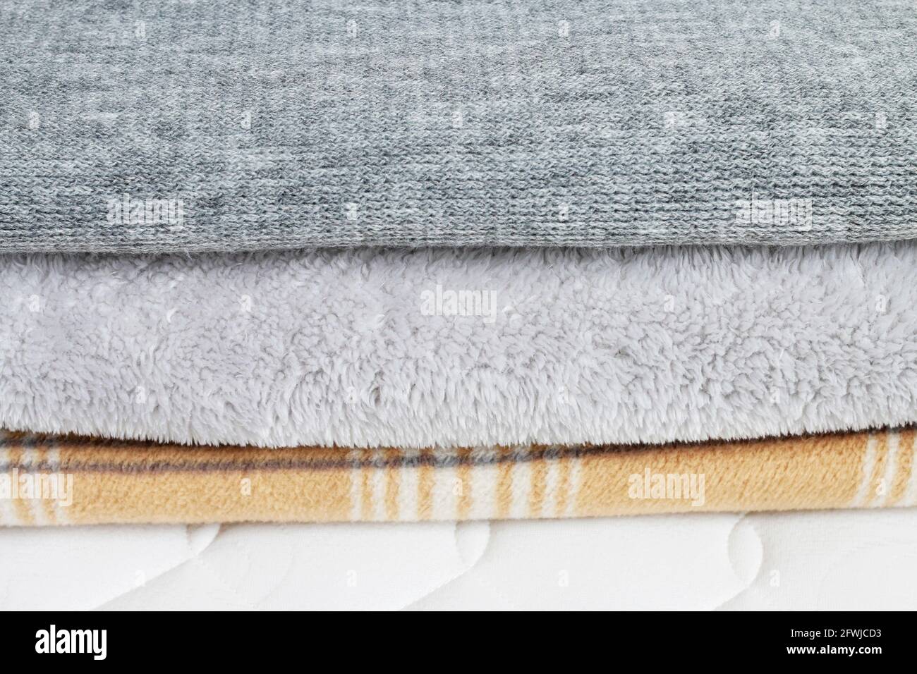 Tre coperte: Grigio e beige sul materasso. Risorse grafiche Foto Stock