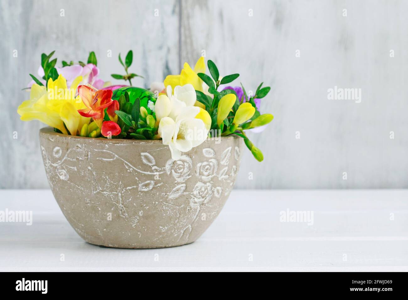 Fai da te centrotavola di Pasqua con uova festive, daffodil di germoglio  fresco, muschio e coniglietto. Composizione della molla. Laboratorio  floreale. Primo piano Foto stock - Alamy