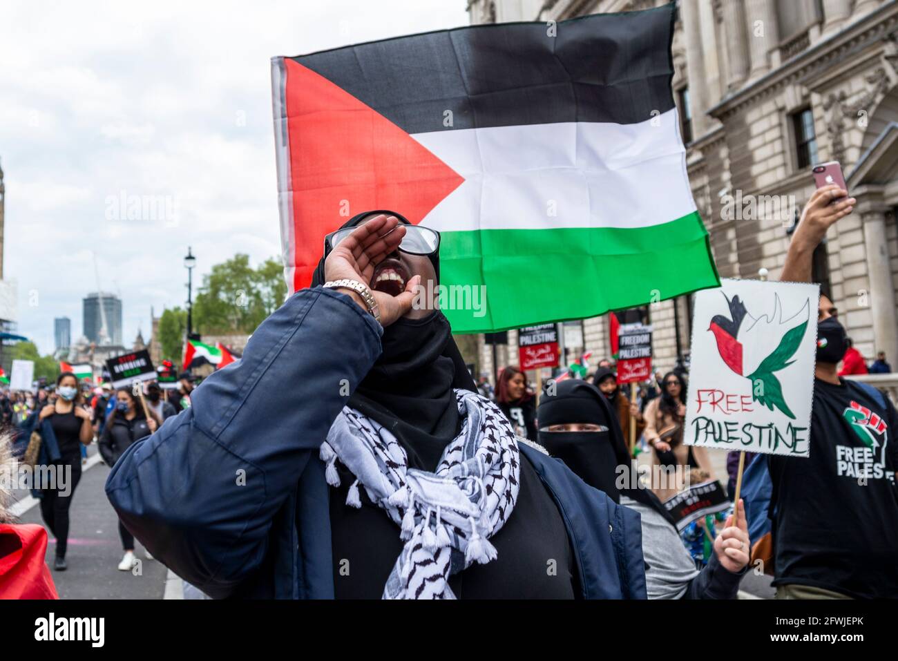 Protetore alla dimostrazione Nazionale per la Palestina, Palestina libera, a Londra, Regno Unito. Canto femminile, con bandiera. Cartello Free Palestine Foto Stock