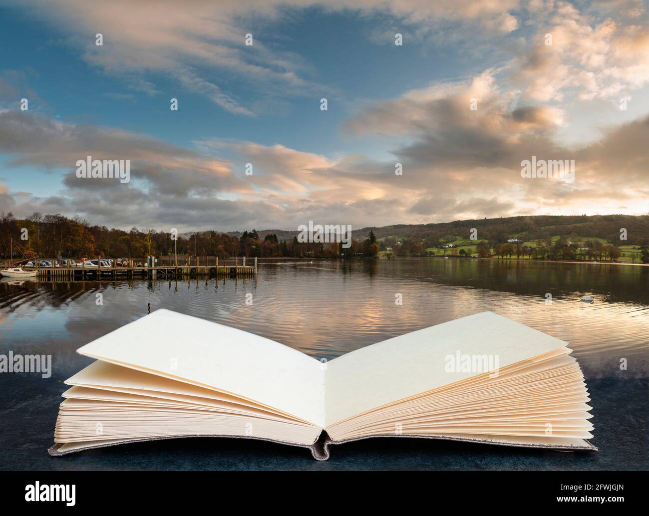 Splendido paesaggio all'alba sull'acqua di Coniston in autunno con nebbia e le nuvole che escono dalle pagine in un libro immaginario Foto Stock