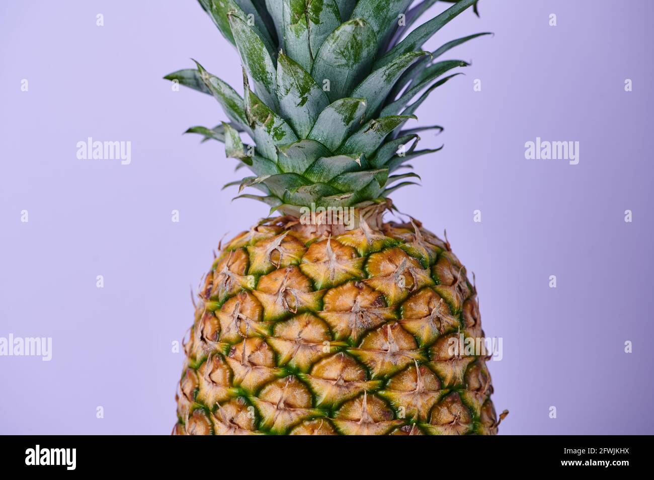mezzo ananas davanti a sfondo violetto Foto Stock