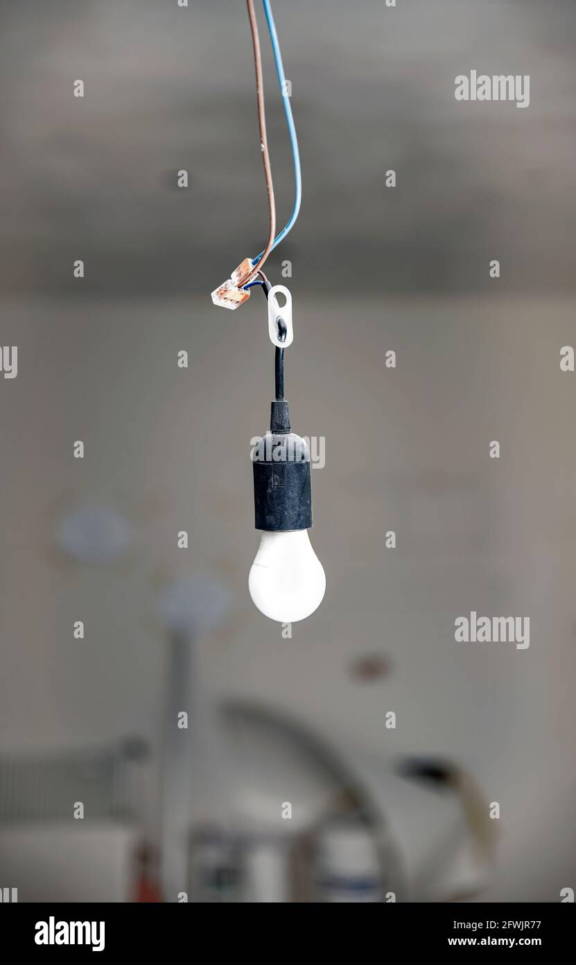 Lampada temporanea in cantiere, appesa al soffitto. Background del cantiere  Foto stock - Alamy