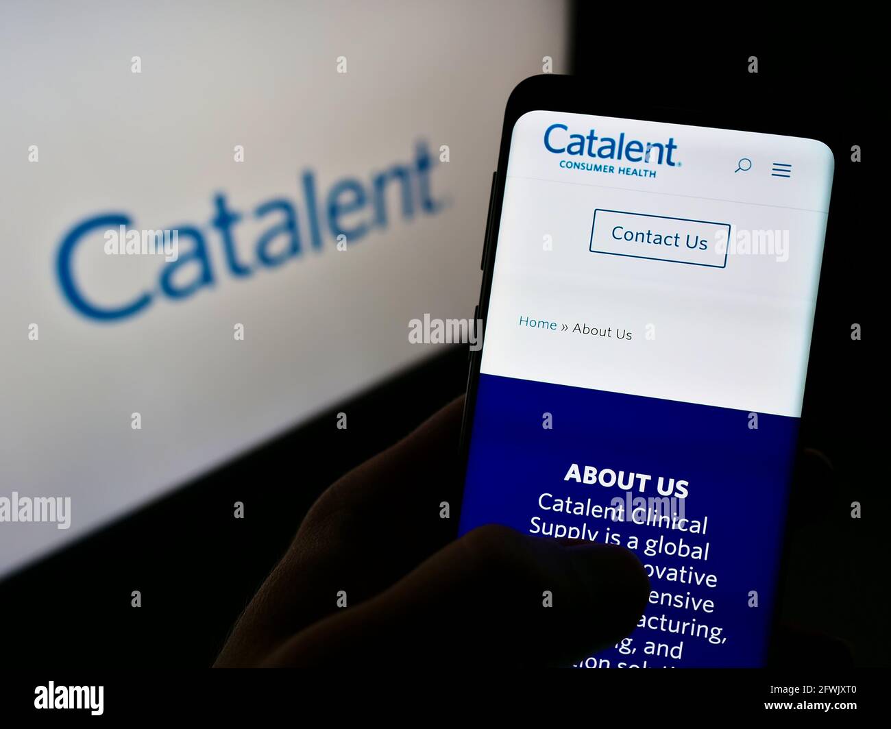 Persona che tiene il telefono mobile con il Web site della società farmaceutica americana Catalent Inc. Sullo schermo davanti al logo. Mettere a fuoco il centro del display del telefono. Foto Stock