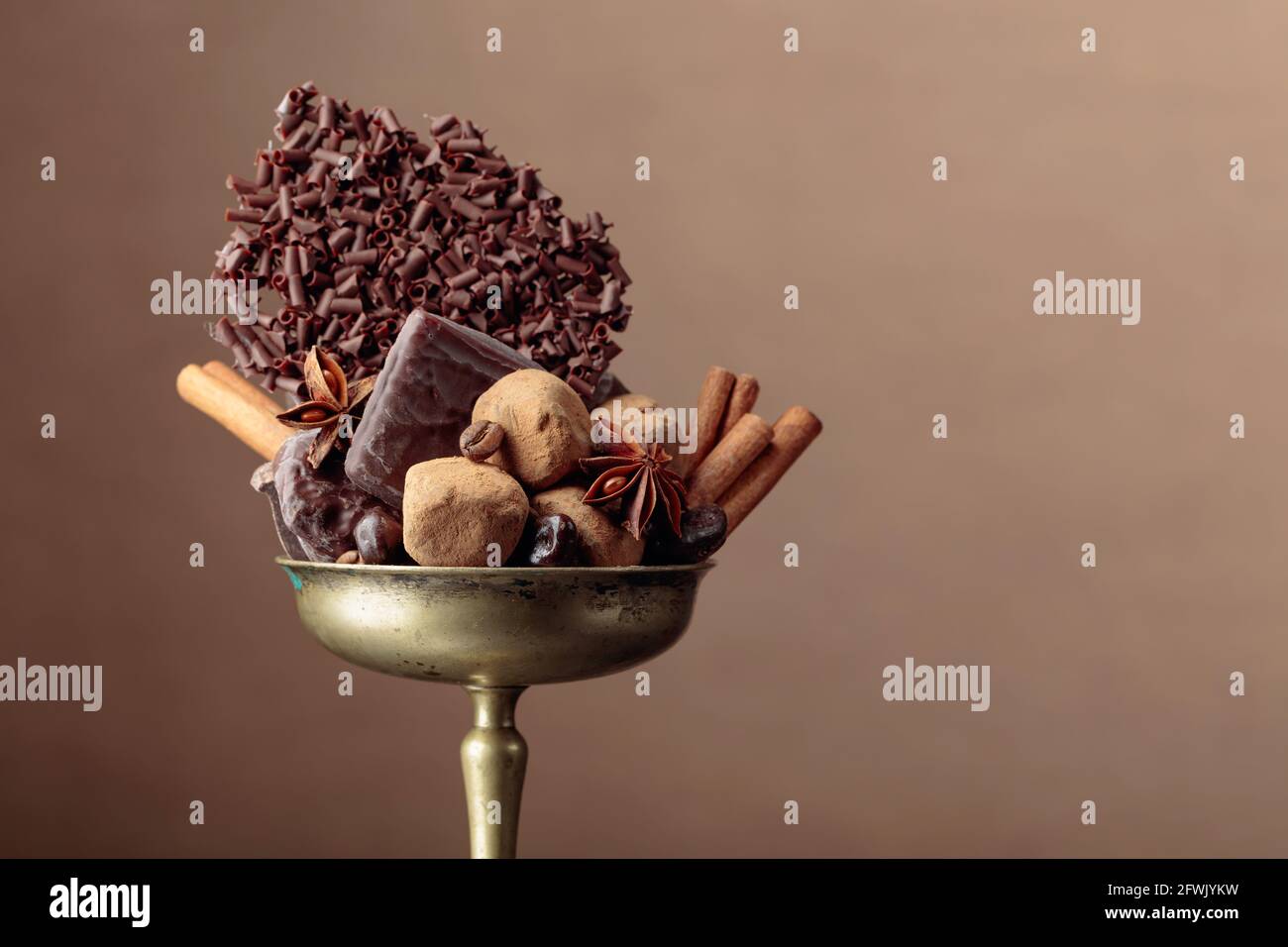 Vari cioccolatini con ingredienti. In una vecchia ciotola di ottone  caramella, chicchi di caffè, cannella, anice e pezzi di cioccolato nero  rotto Foto stock - Alamy