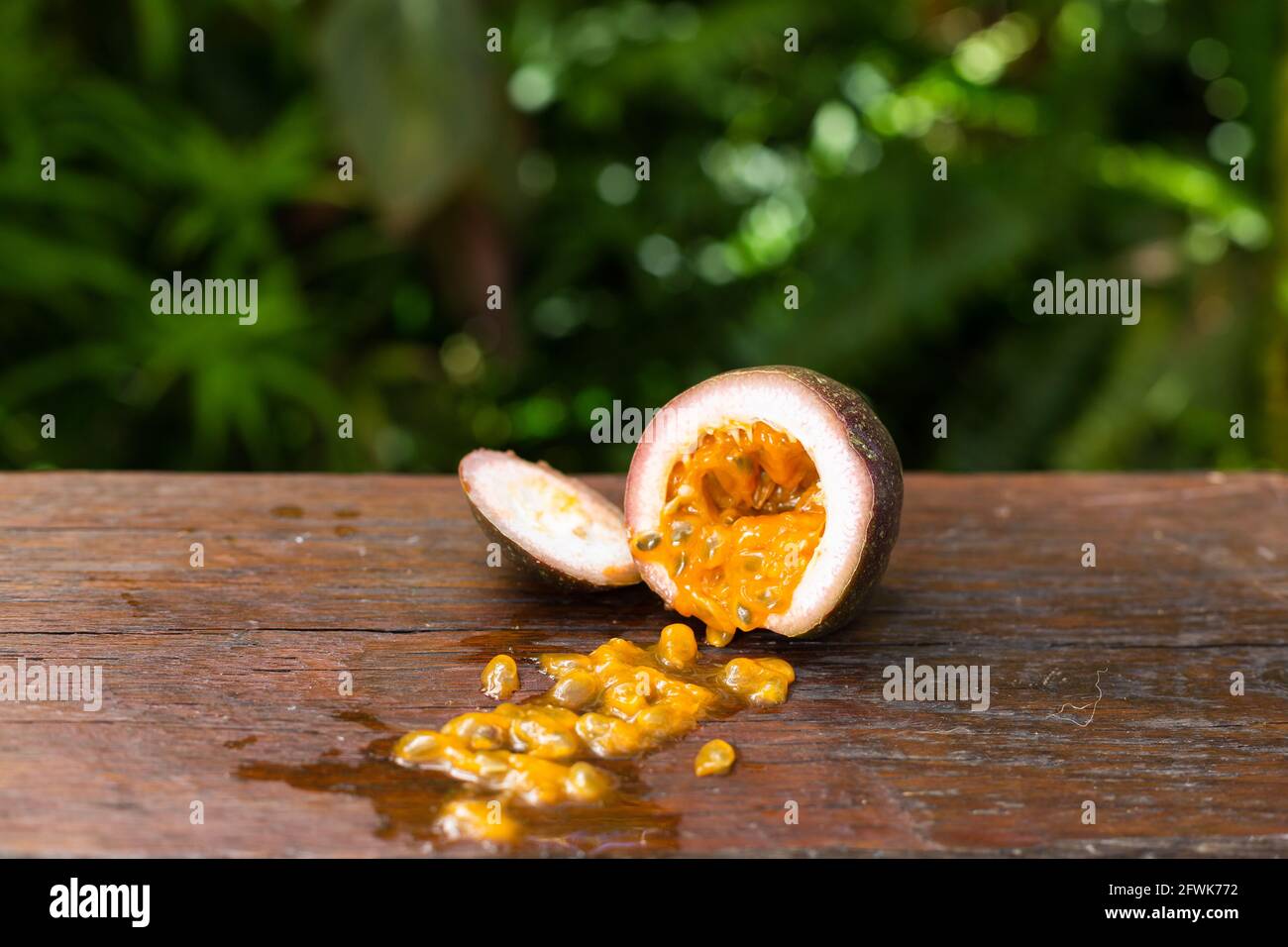 Tazza di passionfruit su tavolo di legno in giardino Foto Stock