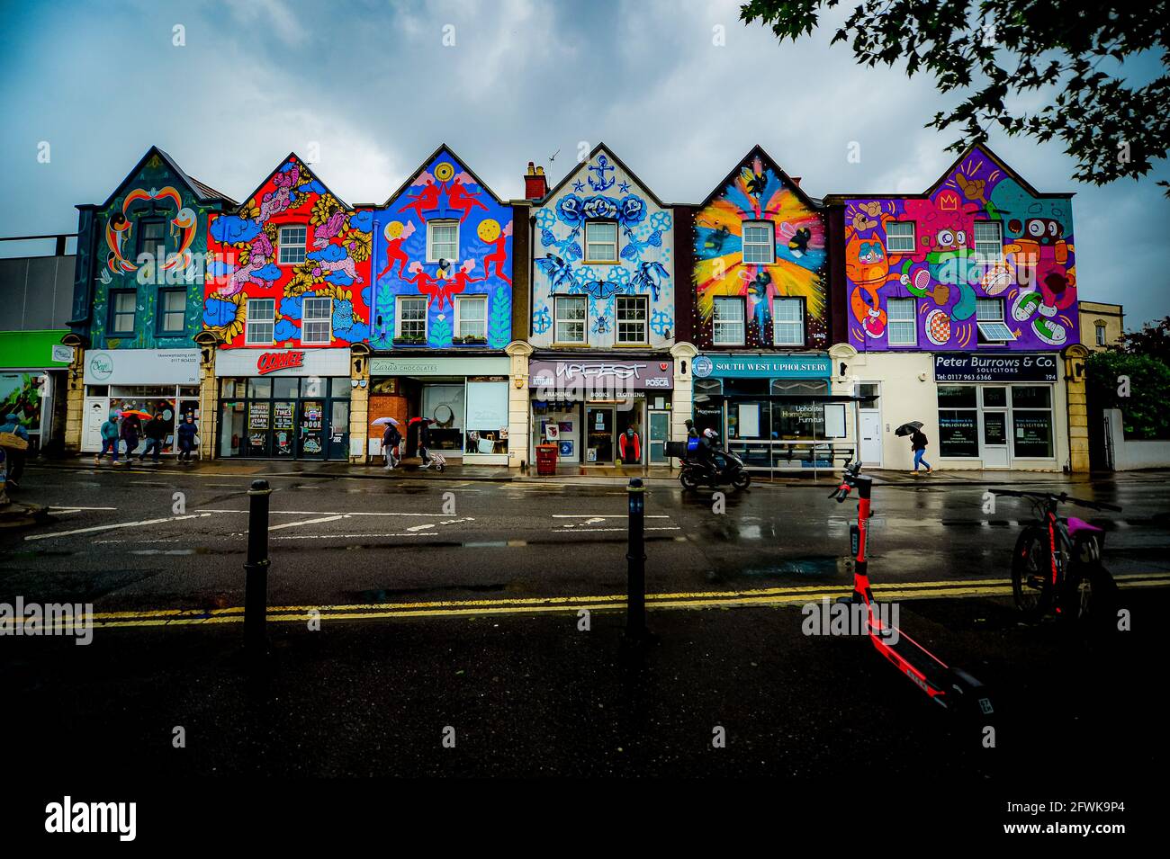 La gente passa davanti a un'installazione d'arte appena installata intitolata 'six Sisters' dipinta sopra i negozi a Bedminster, Bristol. I sei murali graffiti, dipinti da artisti di strada femminili, Lucas antics, Gemma Compton, Bex Glover, Sophie Long, Zoe Power e Emily J Taylor, sono stati finalmente completati dopo cinque anni per completare. I brani finali, di Lucas Antics e Emily J Taylor, sono stati svelati all'inizio di questa settimana. Data immagine: Domenica 23 maggio 2021. Foto Stock