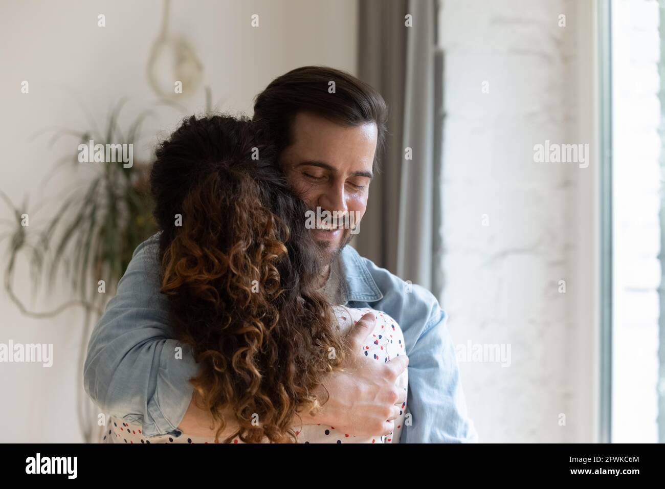Felice sincero giovane uomo coccolante amata donna. Foto Stock
