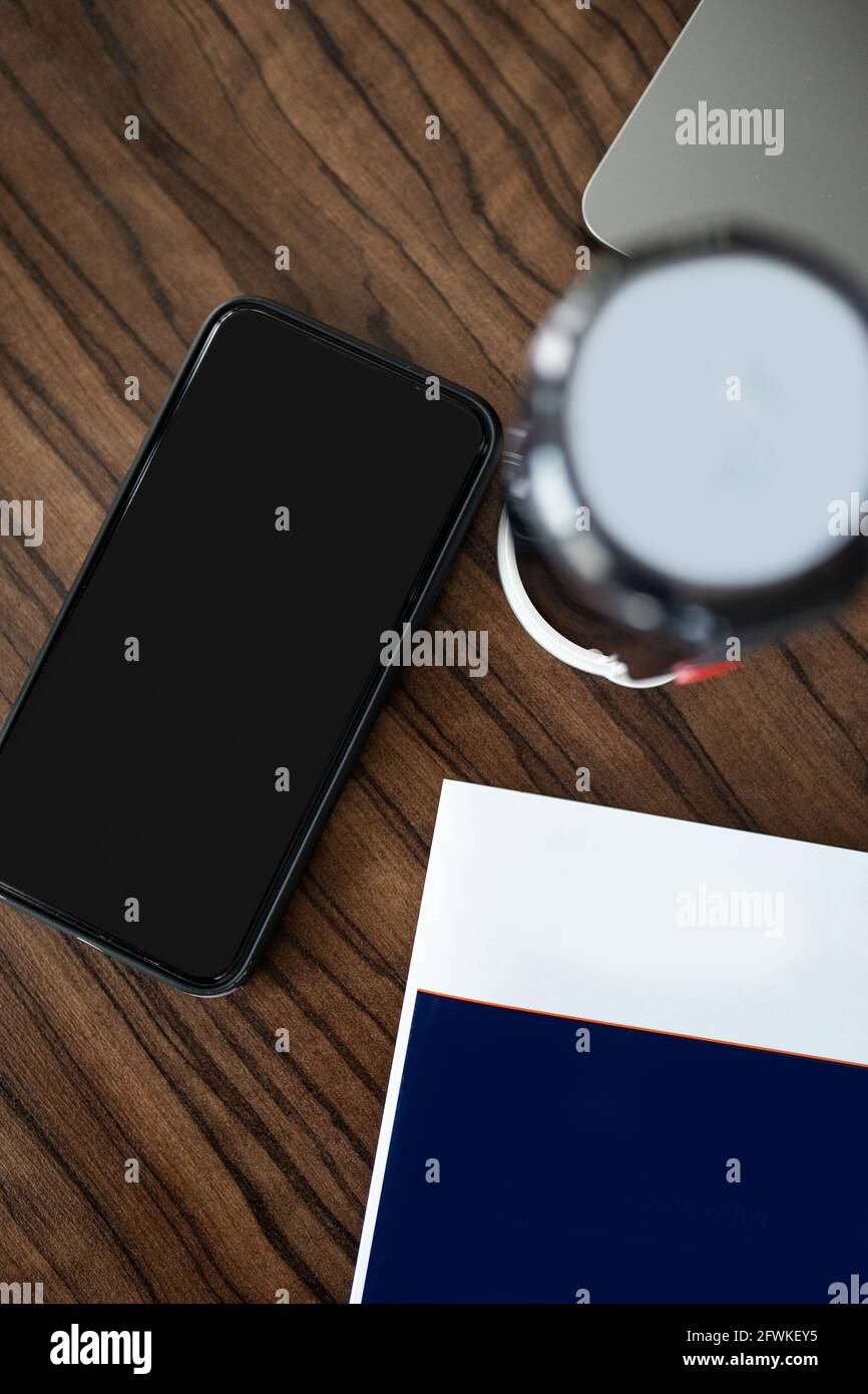 desktop con elementi, stampa e uno smartphone nero. Foto Stock