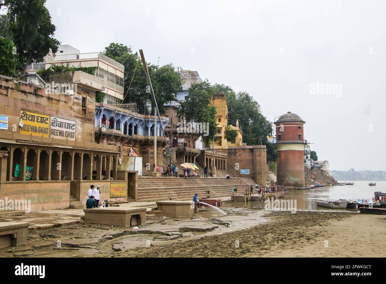 I lavoratori iniziano a ripulire il caos lasciato dopo che il fiume Gange si è allagato durante il monsone a Varanasi, India. Foto Stock