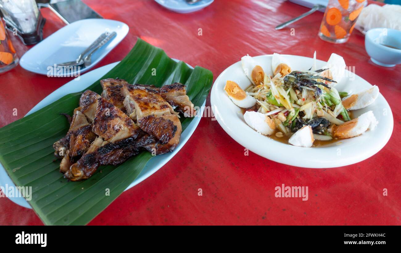 Insalata di papaya e pollo alla griglia cibo tailandese sul tavolo popolare cibo tailandese. Foto Stock