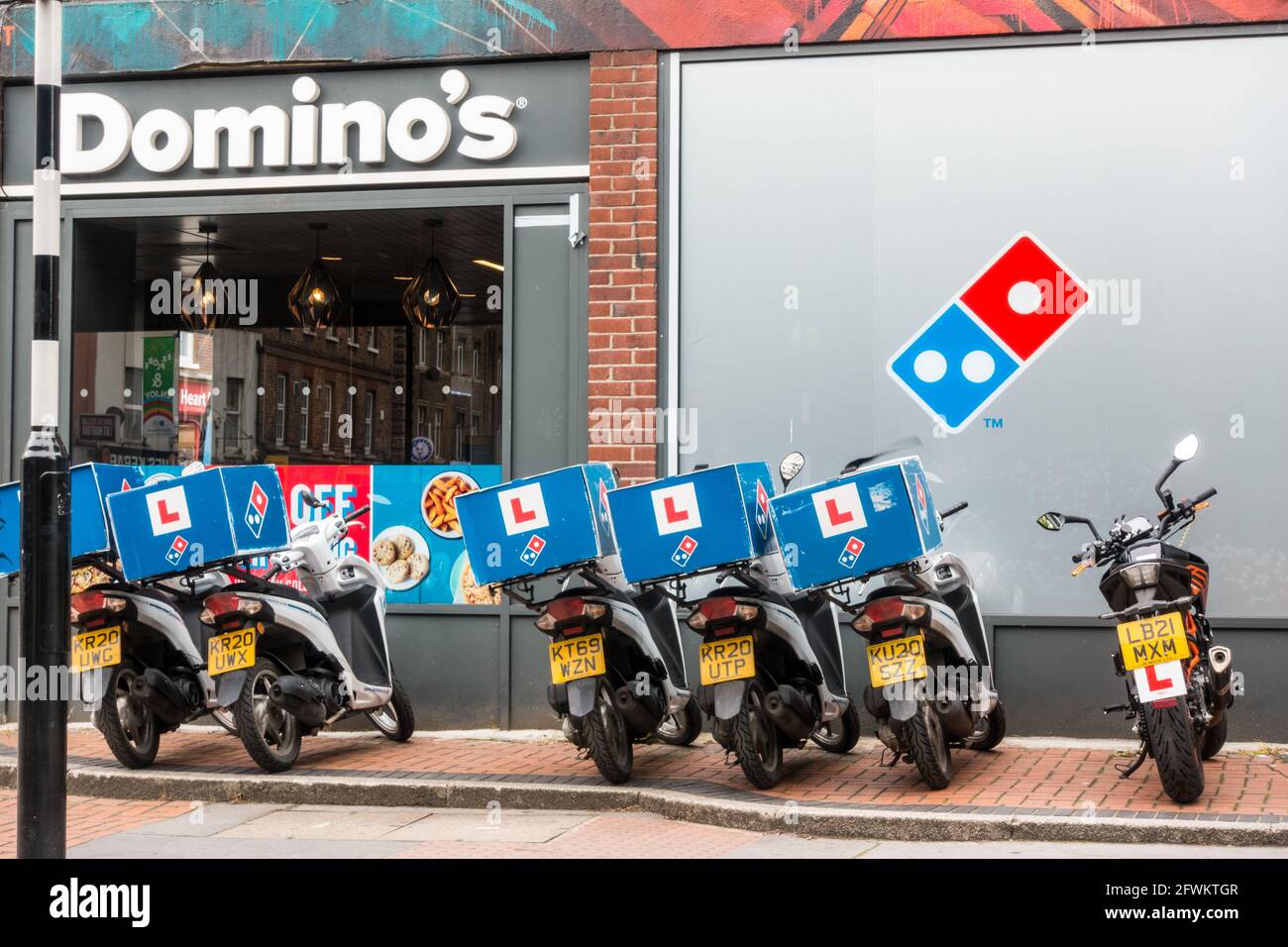 Catena di moto del ristorante Dominos Pizza parcheggiata all'aperto davanti  al negozio Foto stock - Alamy