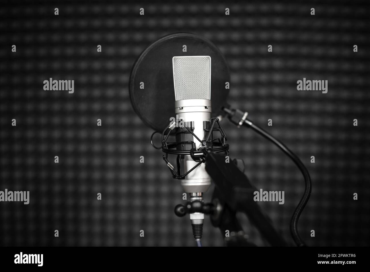 Microfono vocale con supporto antiurto e filtro pop su treppiede professionale in studio di registrazione audio. Foto Stock