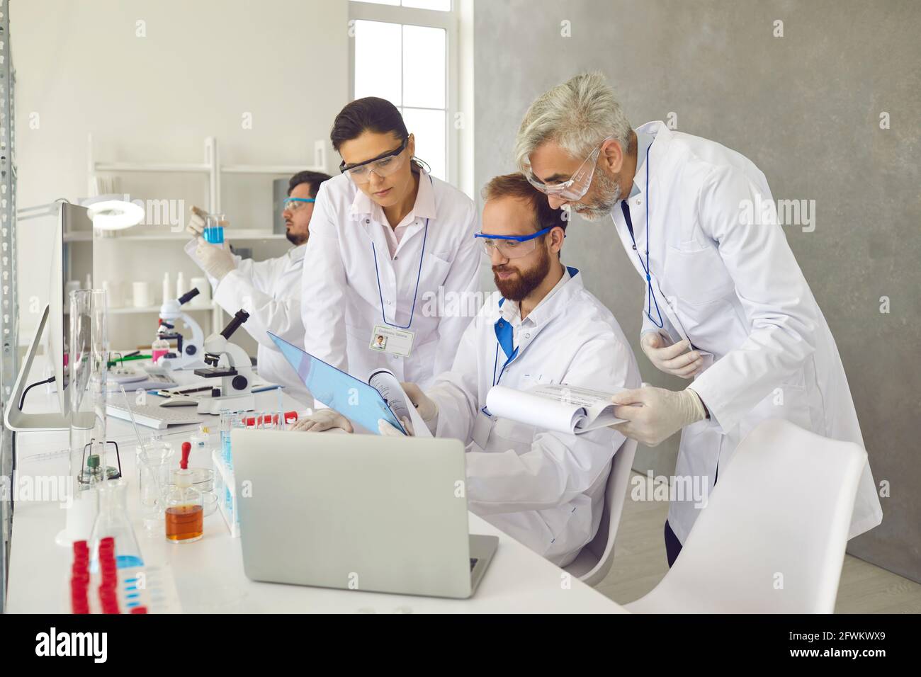Gruppo di scienziati che lavorano in laboratorio, che svolgono ricerche e discutono di report di dati Foto Stock
