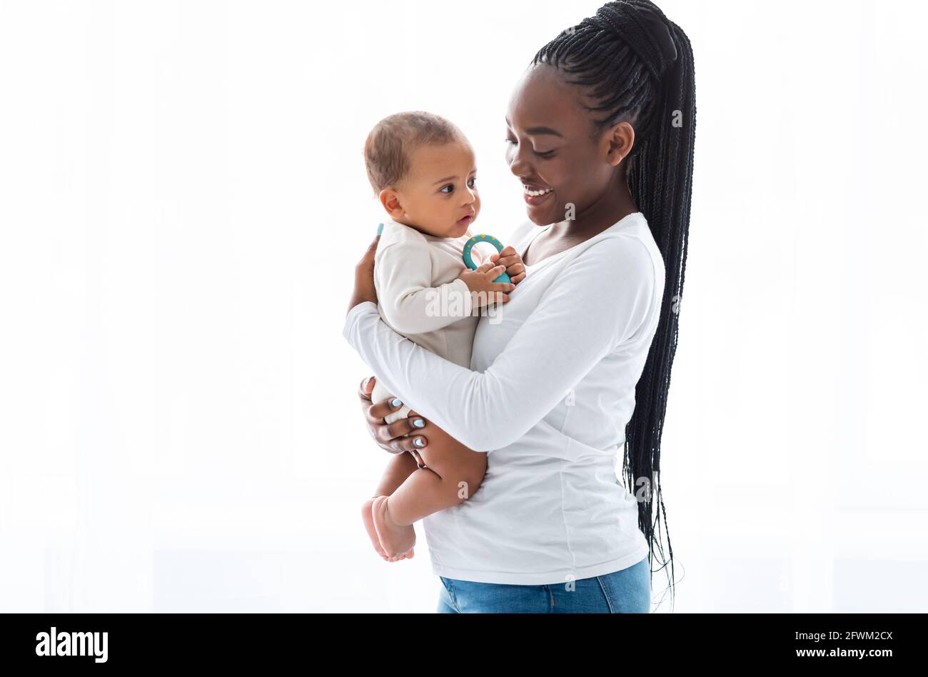 Felice mamma afroamericana abbracciando il suo bambino carino Foto Stock