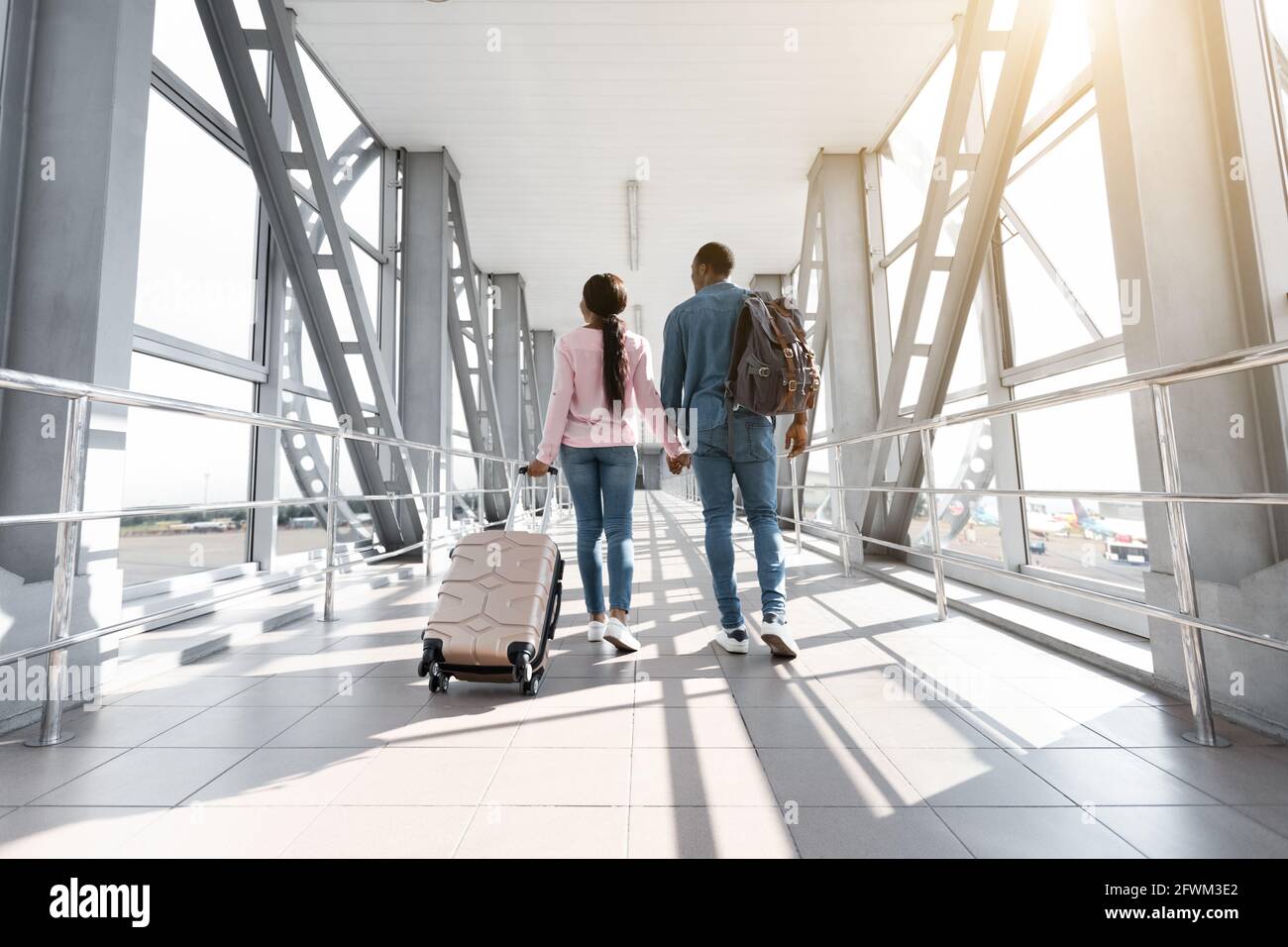 Viaggio di vacanza. Vista posteriore della coppia Nera Passeggiate con bagagli in aeroporto Foto Stock