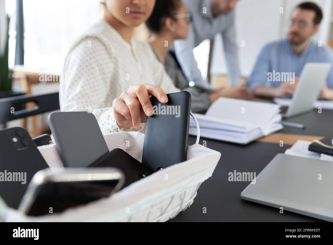 Primo piano donna indiana che mette il telefono nel cestino, nessun cellulare Foto Stock