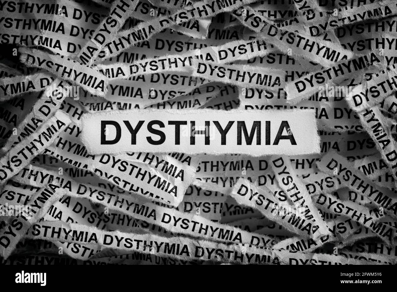 Distimia. Strappato pezzi di carta con le parole Dythymia. Immagine in bianco e nero. Primo piano. Foto Stock