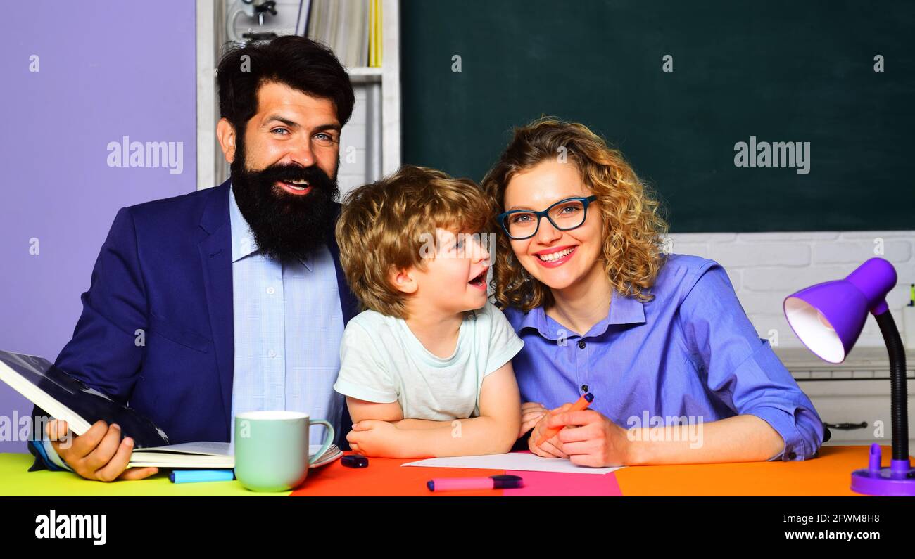 Parenting. I genitori aiutano il figlio a fare il suo lavoro per la scuola. Studente elementare. Mentoring, insegnamento, concetto di istruzione. Foto Stock