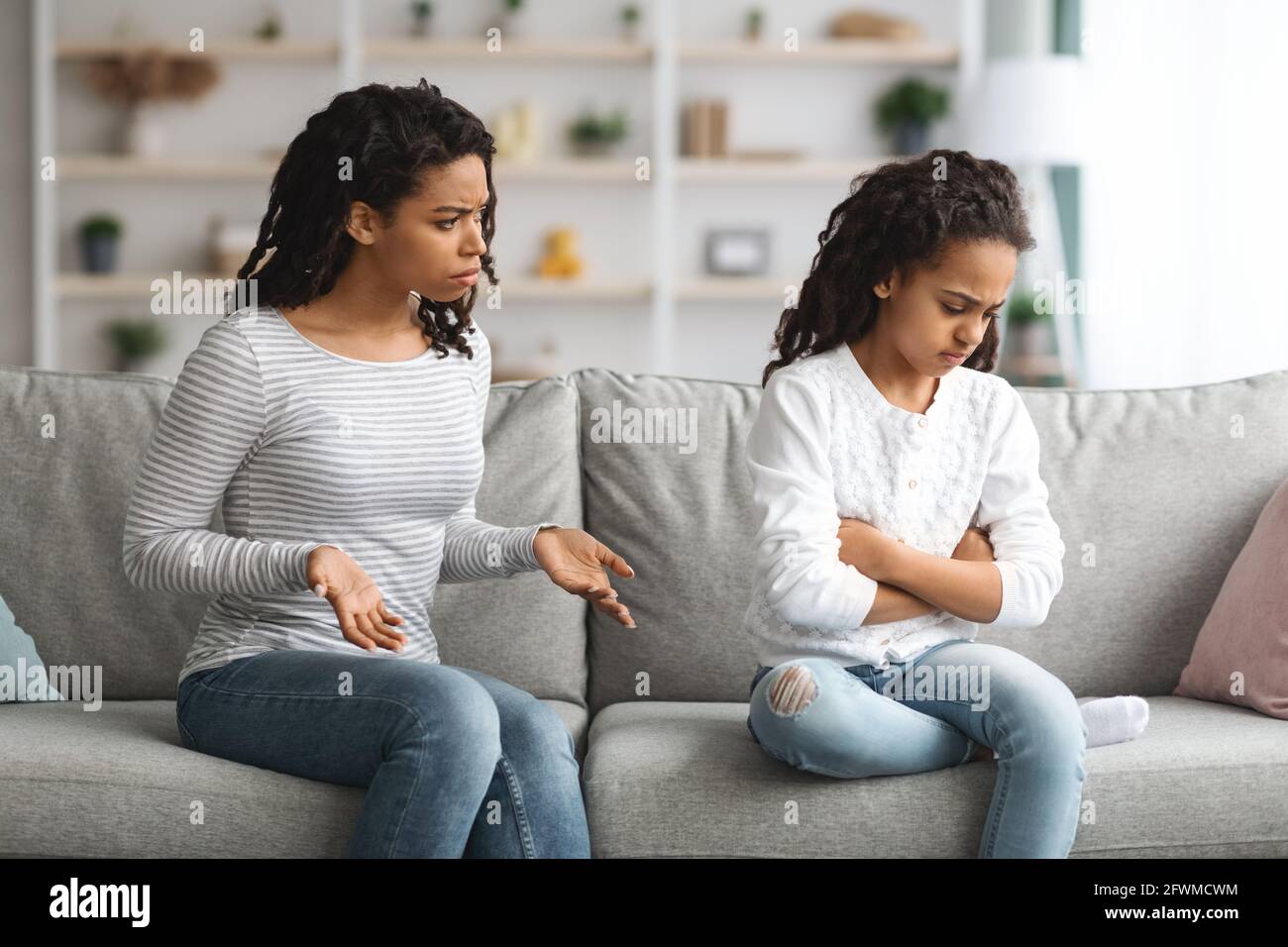 Madre arrabbiata che scolda la figlia, seduta sul divano a casa Foto Stock