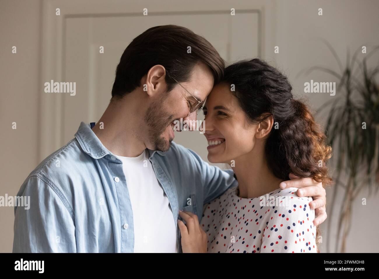 Bonding coppia millennial che mostra i sentimenti teneri a casa. Foto Stock