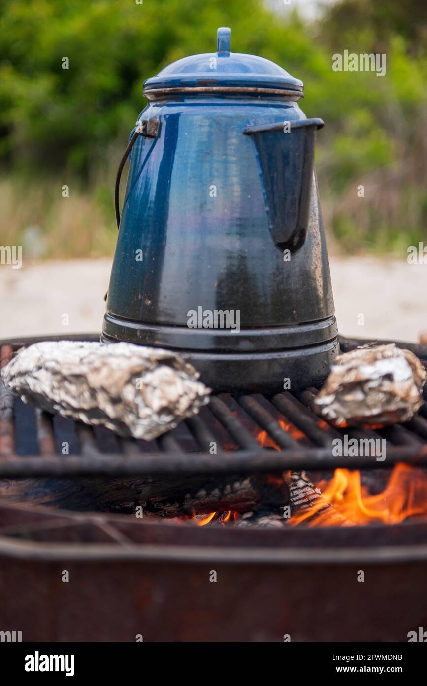 Un pasto camfire di burritos prima colazione e un kettlefull di acqua calda per il caffè scaldare sul fuoco aperto. Foto Stock