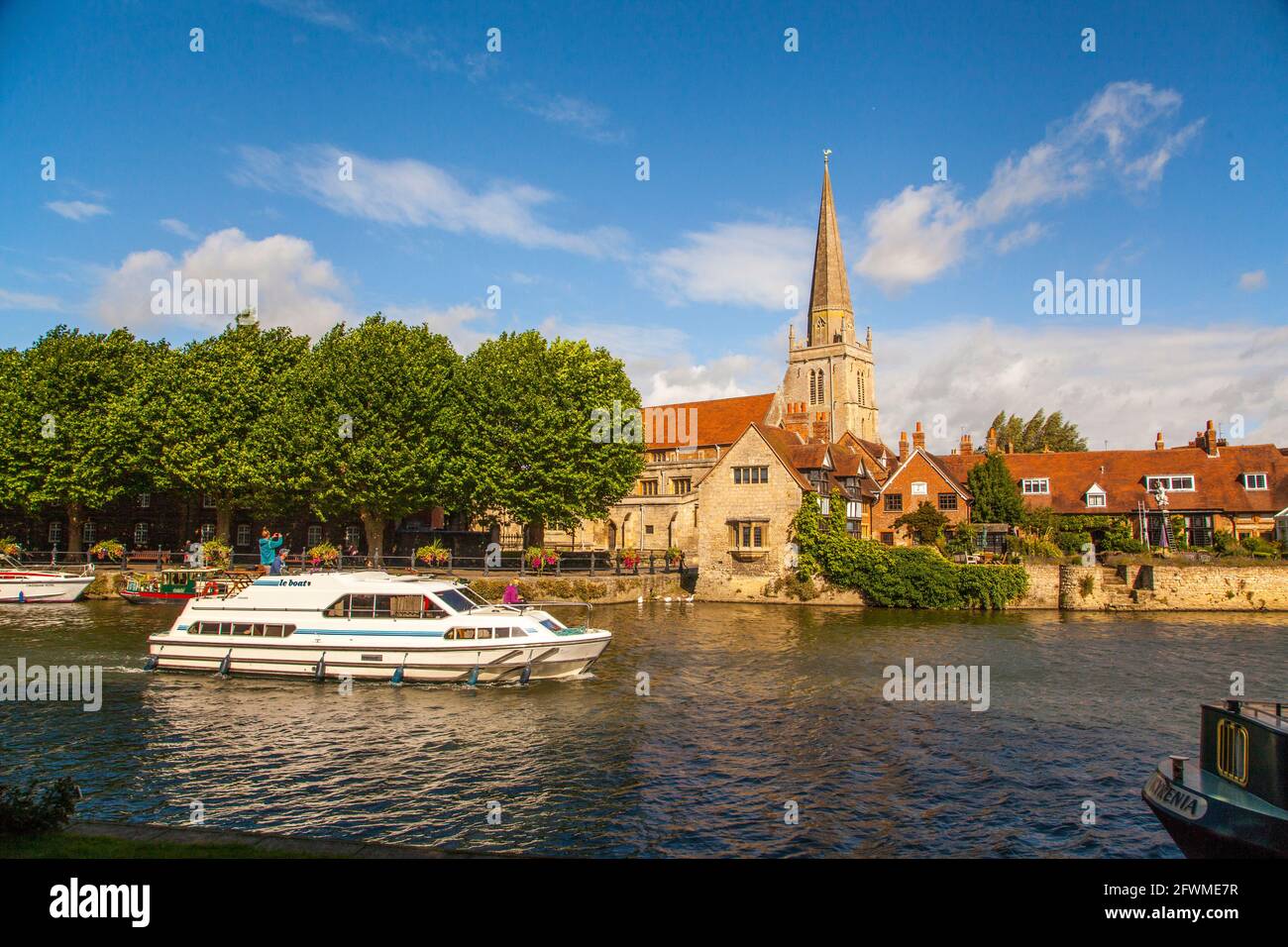 Battello fluviale sul Tamigi passando per la chiesa di St Helen e il molo di St Helen, visto dal sentiero pedonale del Tamigi ad Abingdon sul Tamigi nell'Oxfordshire Foto Stock