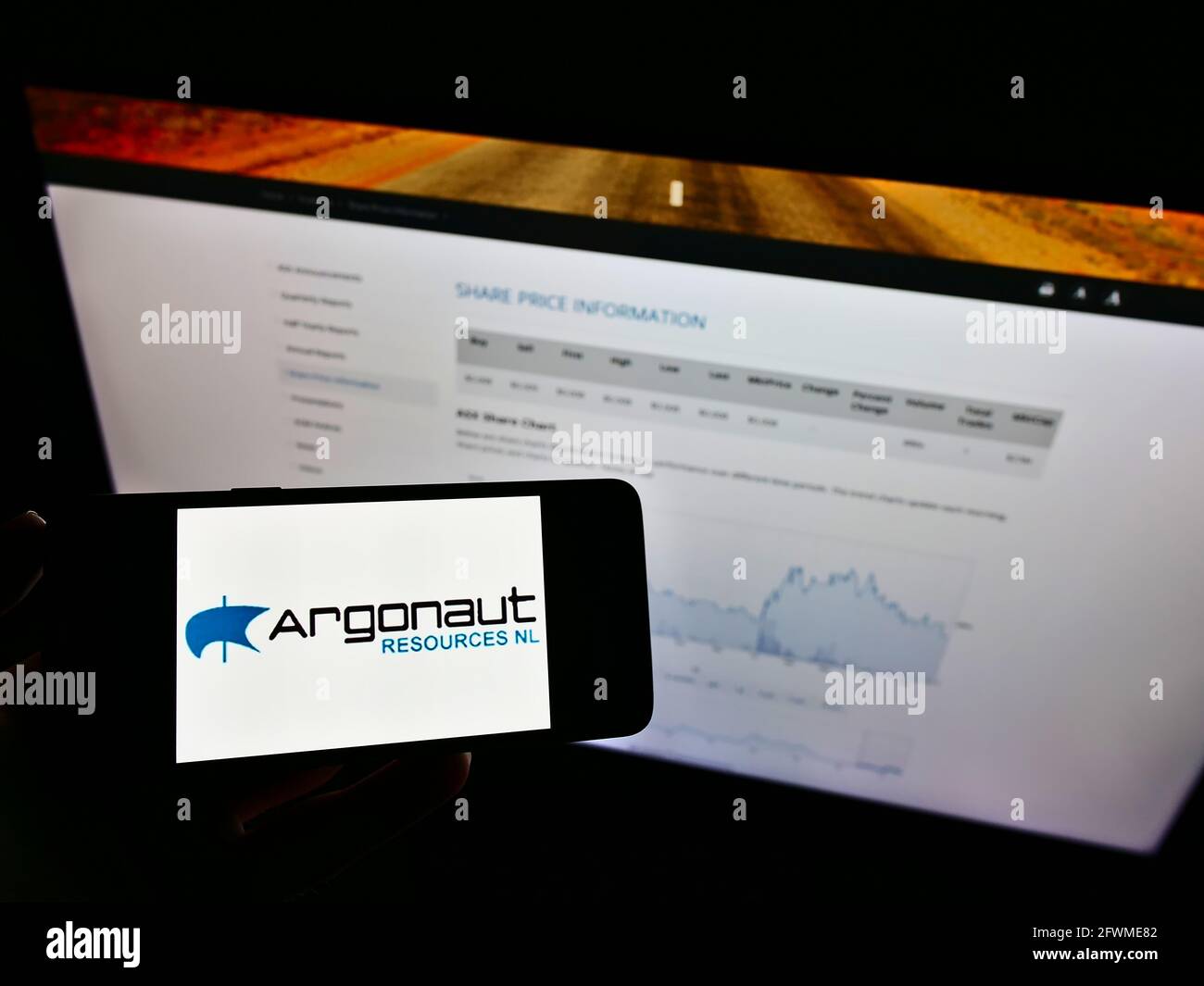 Persona che detiene cellulare con il logo commerciale della società mineraria australiana Argonaut risorse NL sullo schermo di fronte al sito web. Mettere a fuoco il display del telefono. Foto Stock