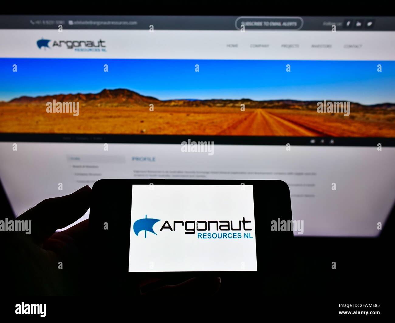 Persona che tiene il telefono mobile con il logo della società mineraria australiana Argonaut risorse NL sullo schermo davanti alla pagina web. Mettere a fuoco il display del telefono. Foto Stock