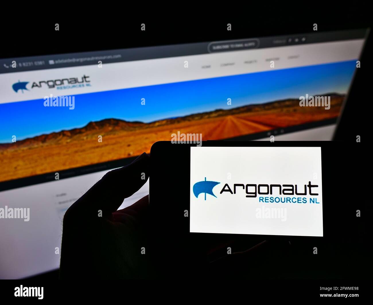 Persona che detiene smartphone con il logo della società mineraria australiana Argonaut risorse NL sullo schermo di fronte al sito web. Mettere a fuoco il display del telefono. Foto Stock