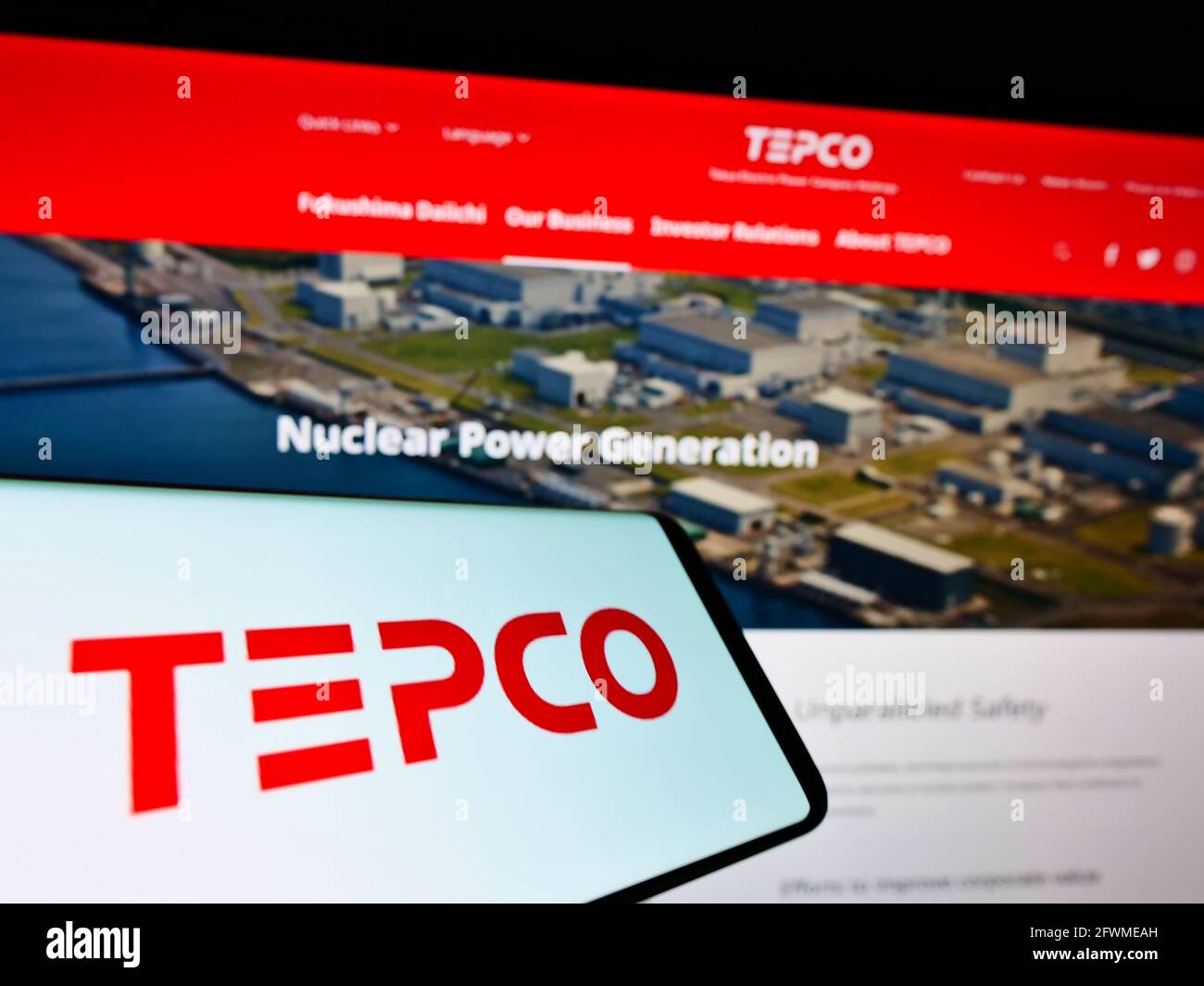 Telefono cellulare con logo di Tokyo Electric Power Company Holdings Inc. (TEPCO) sullo schermo davanti al sito web. Mettere a fuoco il centro-destra del display del telefono. Foto Stock