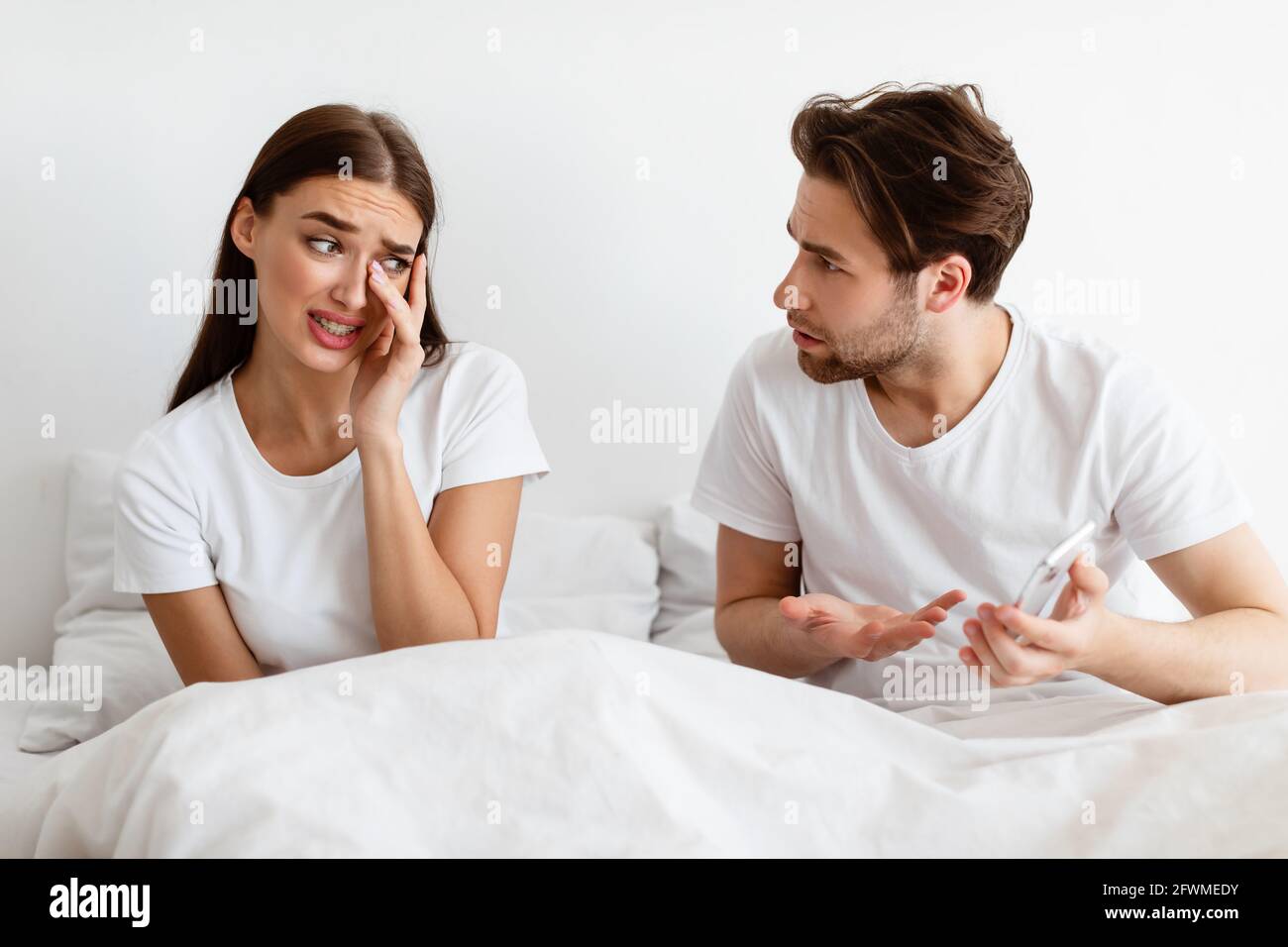 Sposo geloso che mostra la moglie di Cheating Cellphone sospettando Affair  in Camera da Letto Foto stock - Alamy