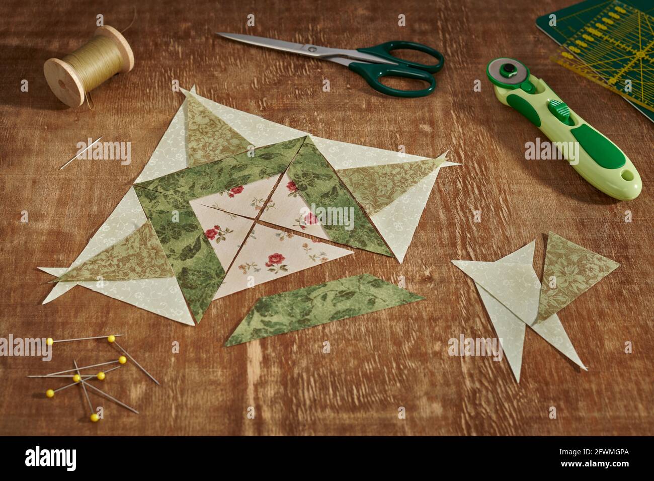 Pezzetti di tessuto disposti a forma di blocco di patchwork, accessori per cucire e trapuntare. Foto Stock