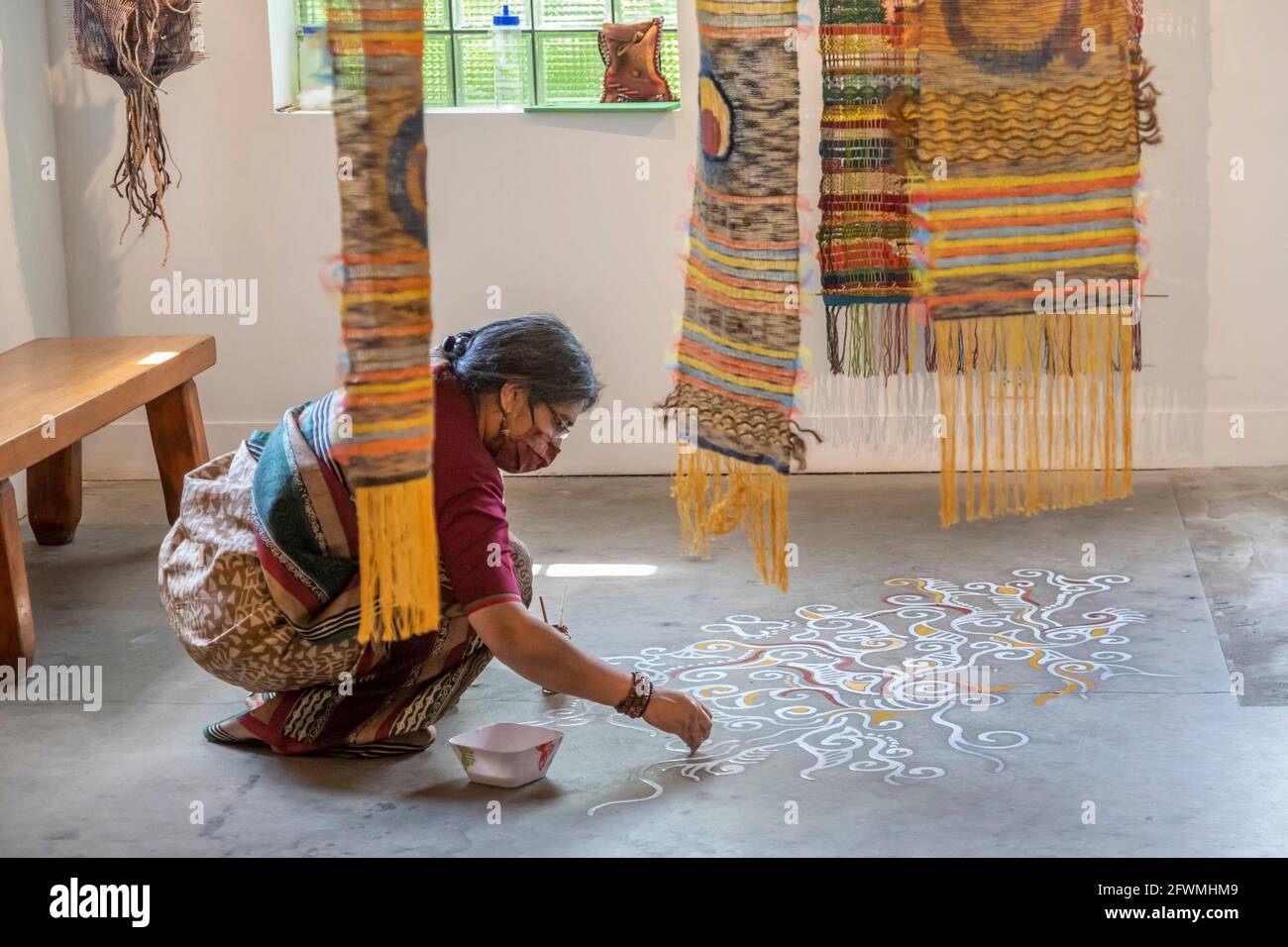 Hamtramck, Michigan - Boisali Biswas dimostra l'arte di Alpona, pittura effimera del pavimento che è praticata nel Bengala occidentale in India e a Bangla Foto Stock