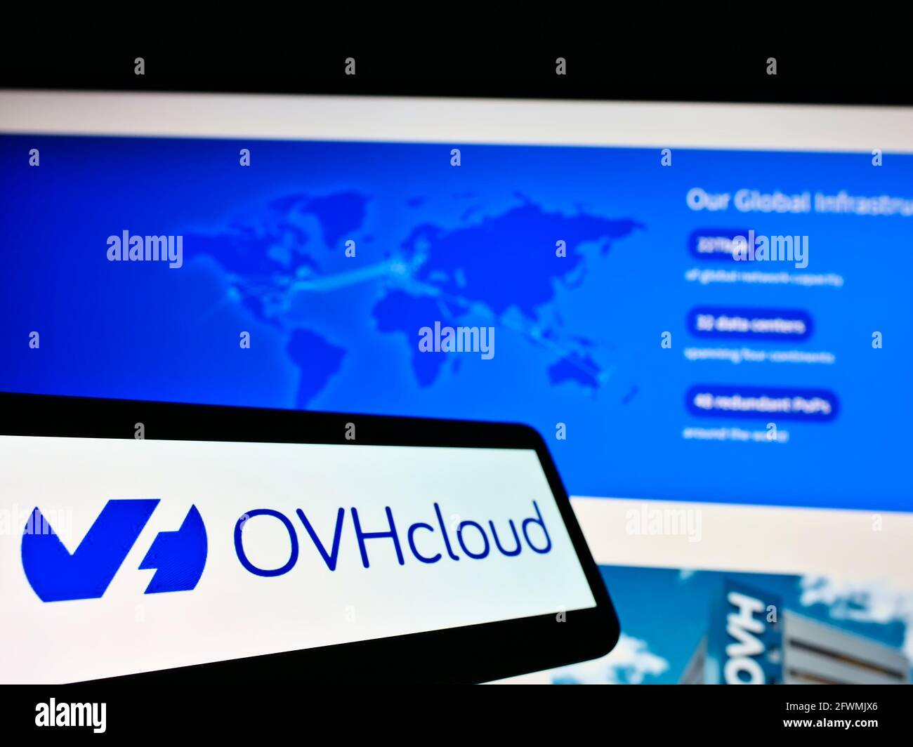 Telefono cellulare con logo del provider francese di cloud computing OVH Groupe SAS sullo schermo davanti al sito Web. Mettere a fuoco al centro-sinistra del display del telefono. Foto Stock