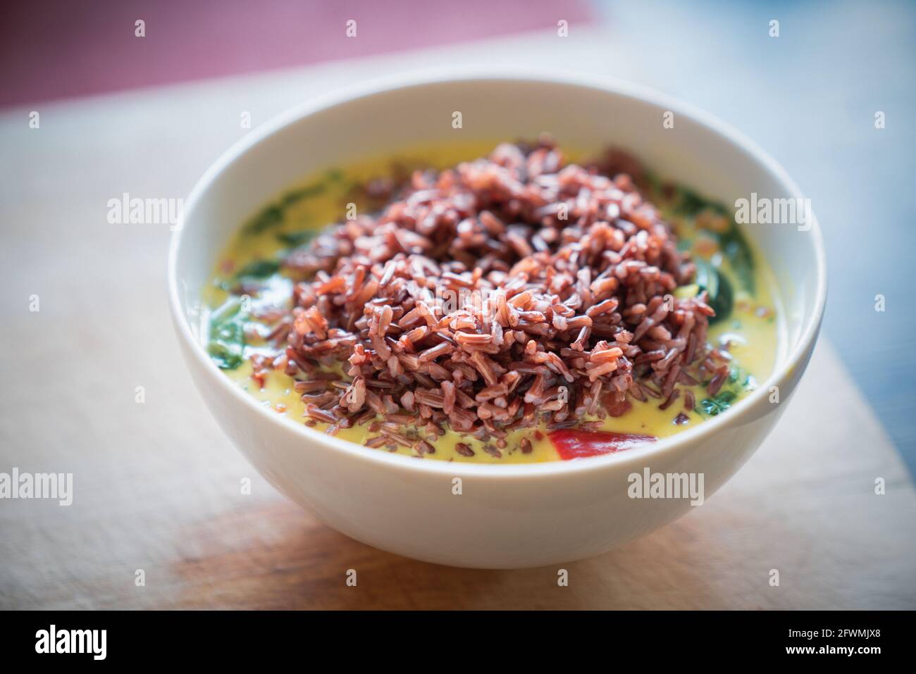 Ciotola di zucchine, lenticchie e spezzatino di spinaci con riso rosso Foto Stock