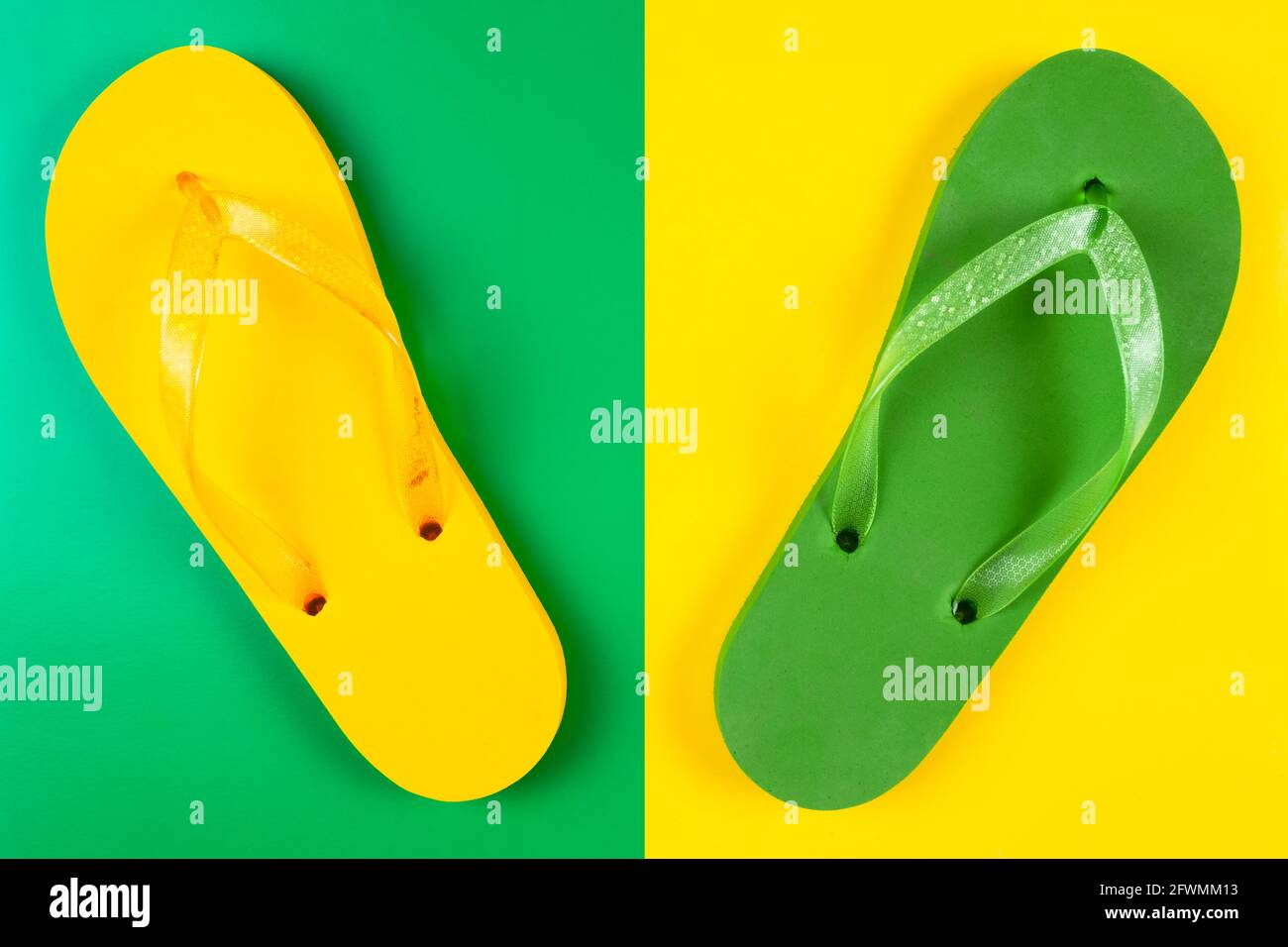 infradito in gomma verde e gialla su verde e giallo sfondo Foto Stock