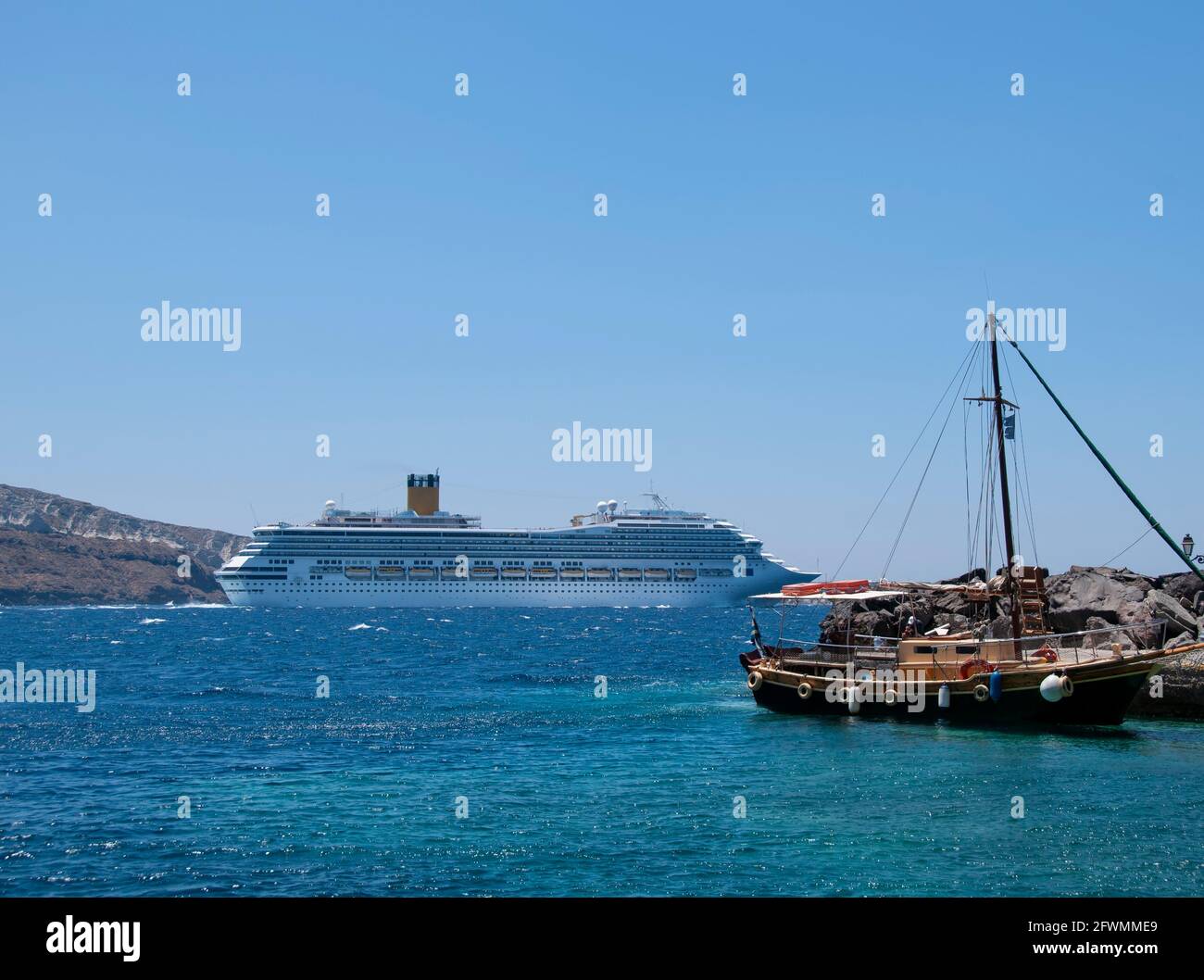 Navi da crociera in Grecia che navigano nella caldera dell'isola di Santorini. Sullo sfondo il cielo blu e il Mar Egeo Foto Stock